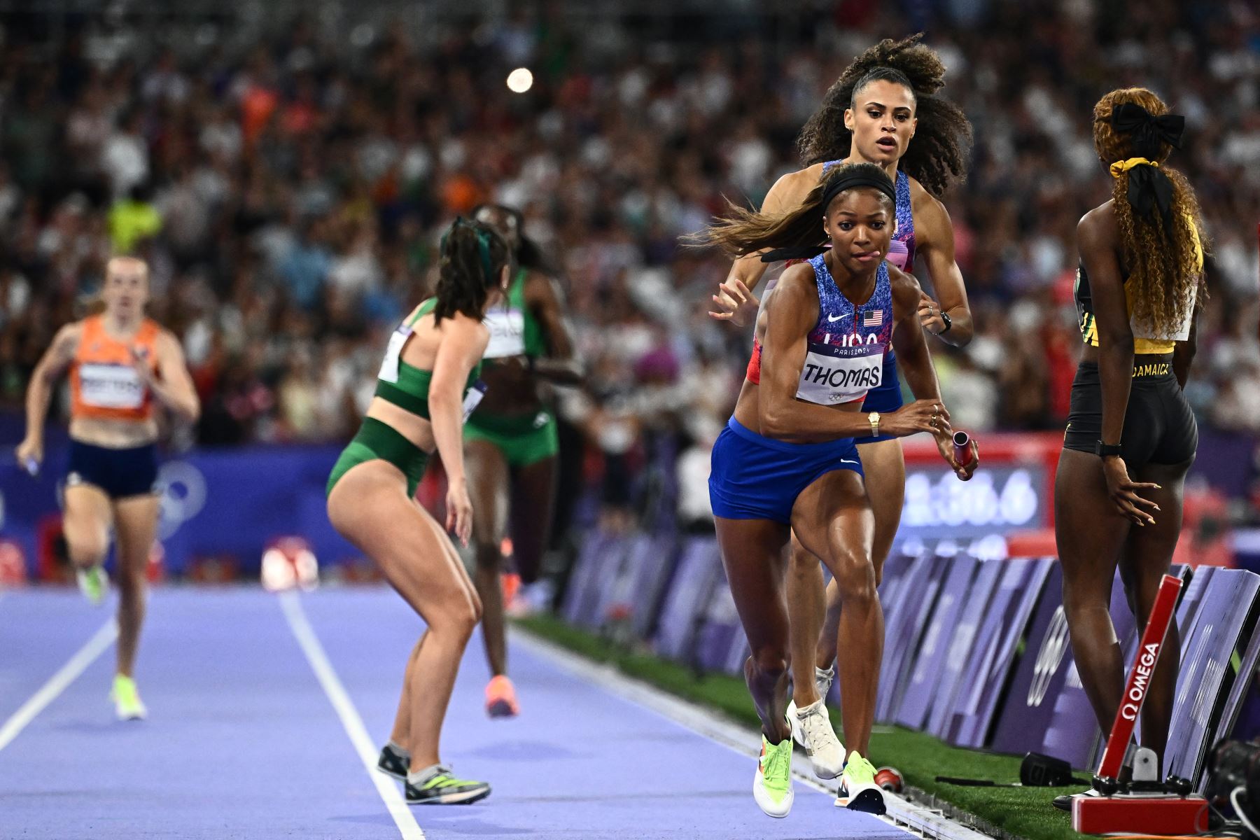 La estadounidense Gabrielle Thomas compite mientras Shiann Salmon  de Jamaica sale de la pista mientras los atletas compiten en la final femenina de relevos de 4x400m del evento de atletismo en los Juegos Olímpicos de París 2024.
Foto: AFP