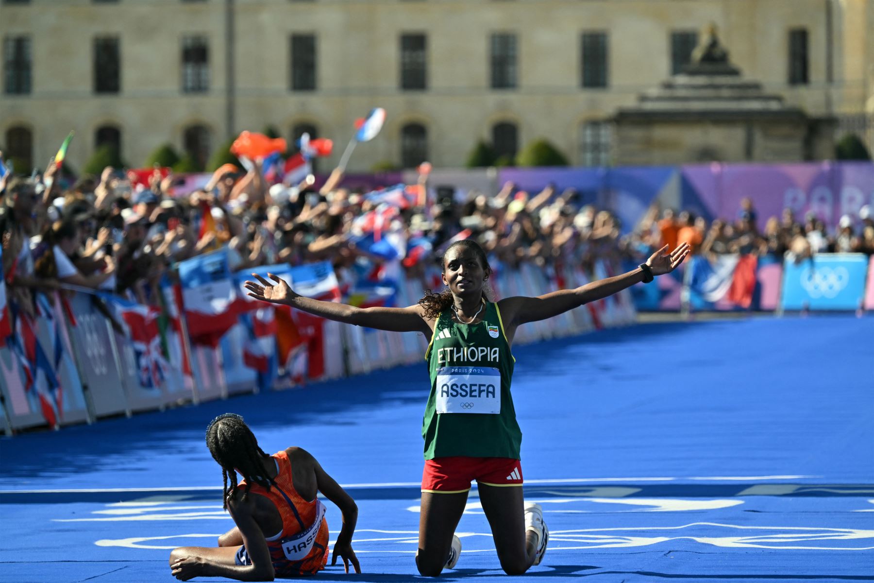 La medallista de oro holandesa Sifan Hassan  se desploma después de cruzar la meta en primer lugar, seguida por la medallista de plata etíope Tigst Assefa en el maratón femenino de la prueba de atletismo de los Juegos Olímpicos de París 2024. AFP