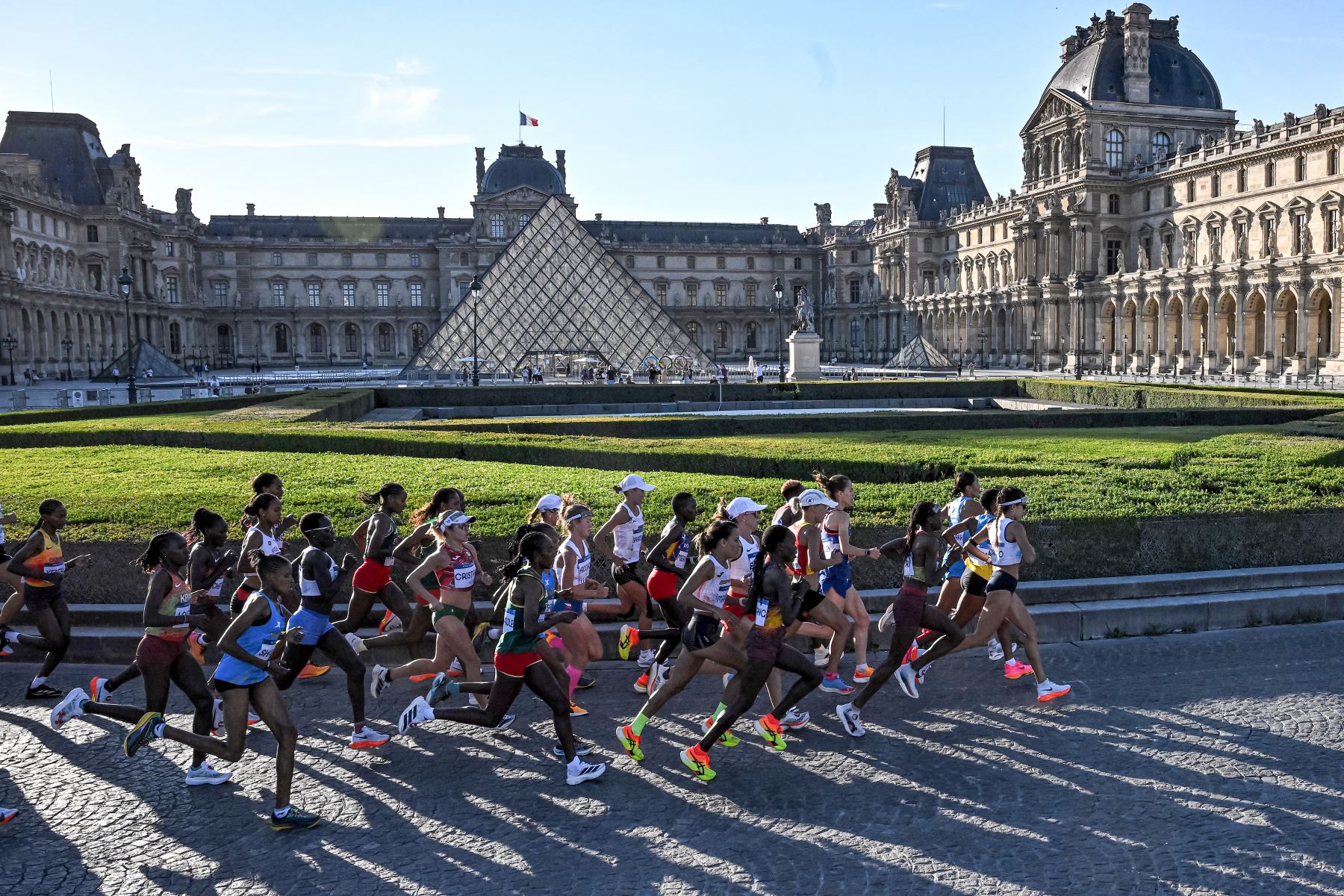 Los atletas corren junto a la Pyramide du Louvre, diseñada por el arquitecto chino-estadounidense Ieoh Ming Pei, mientras compiten en el maratón femenino de la prueba de atletismo de los Juegos Olímpicos de París 2024. AFP