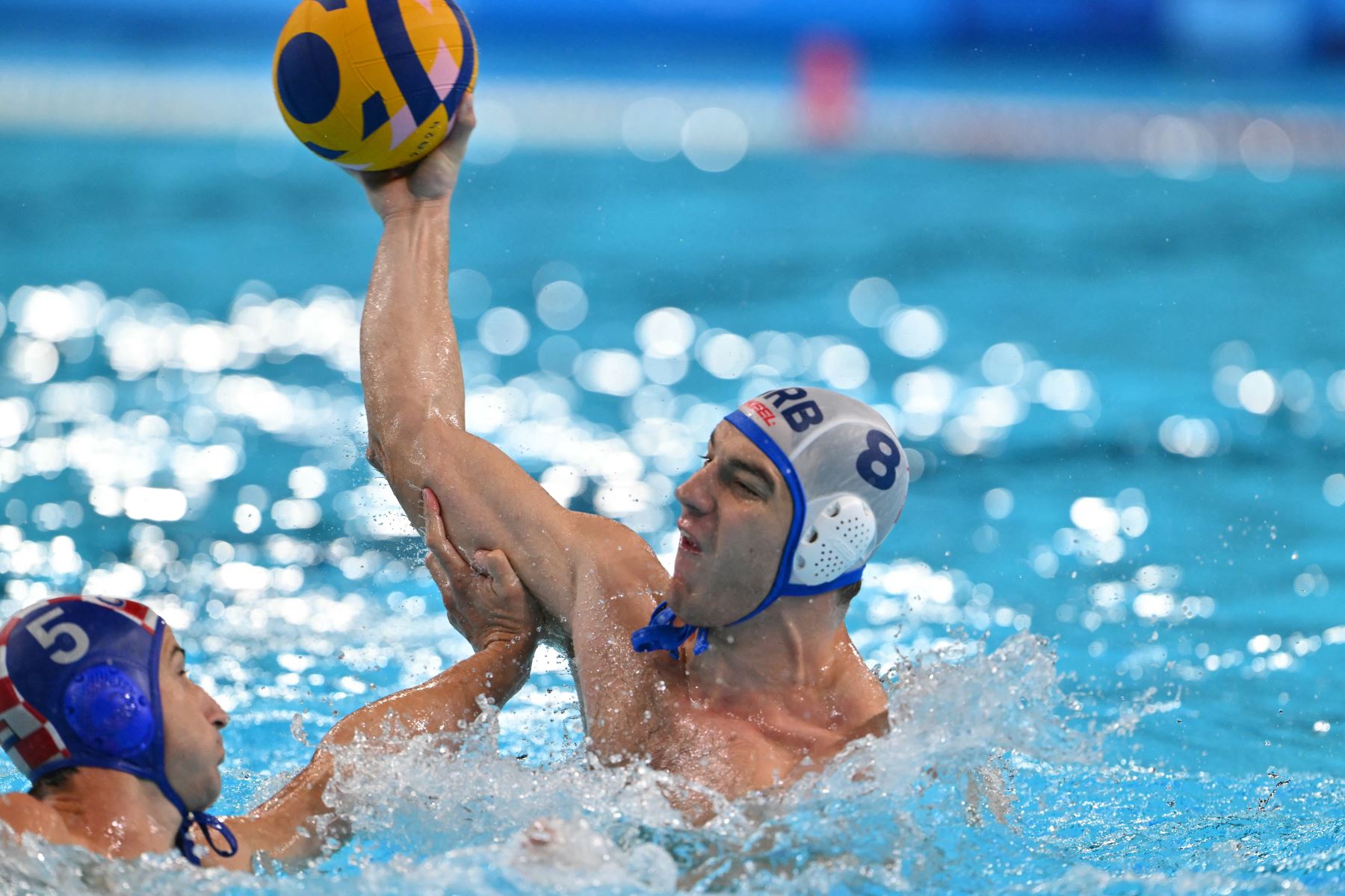 El croata Maro Jokovic lucha por el balón con el serbio  Nikola Jaksic en el partido por la medalla de oro de waterpolo masculino entre Serbia y Croacia durante los Juegos Olímpicos de París 2024. AFP