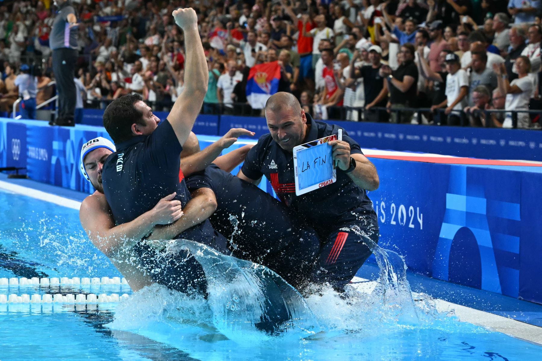 Los jugadores de Serbia celebran con su entrenador tras ganar el partido por la medalla de oro masculina de waterpolo entre Serbia y Croacia durante los Juegos Olímpicos de París 2024. AFP