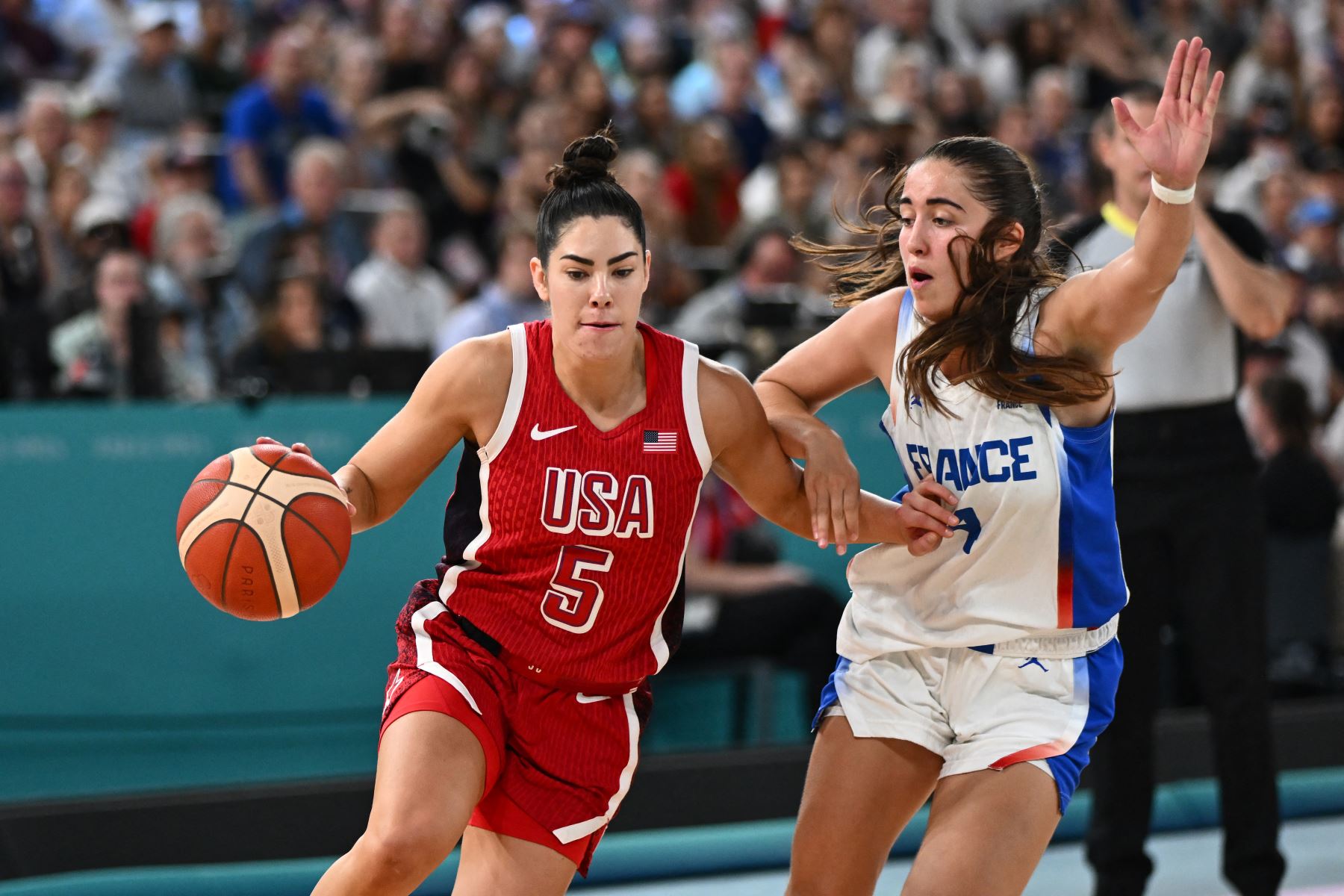 La estadounidense Kelsey Plum flanquea a la francesa  Marine Fauthoux en el partido de baloncesto femenino por la medalla de oro entre Francia y Estados Unidos durante los Juegos Olímpicos de París 2024. AFP