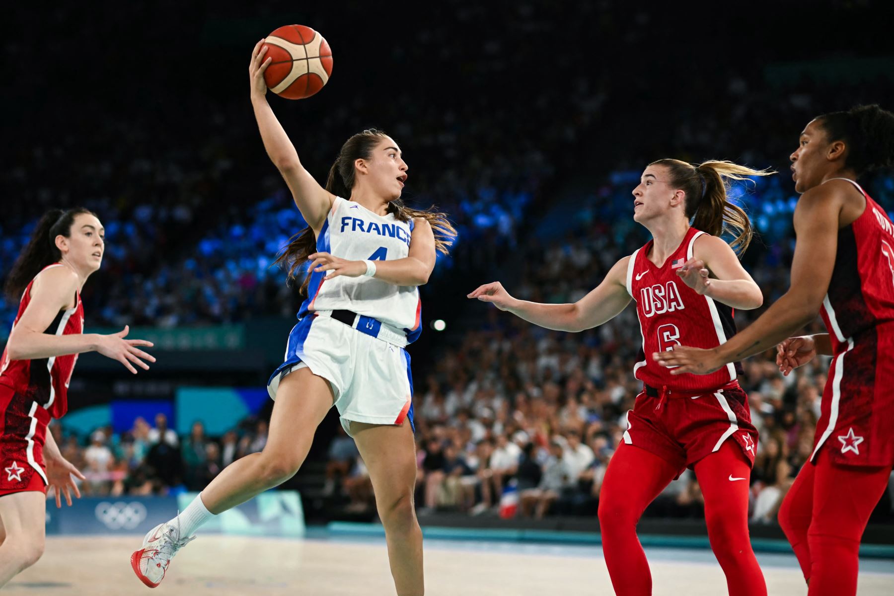 La francesa Marine Fauthoux pasa el balón sobre la estadounidense  Sabrina Ionescu  en el partido de baloncesto femenino por la medalla de oro entre Francia y Estados Unidos durante los Juegos Olímpicos de París 2024. AFP