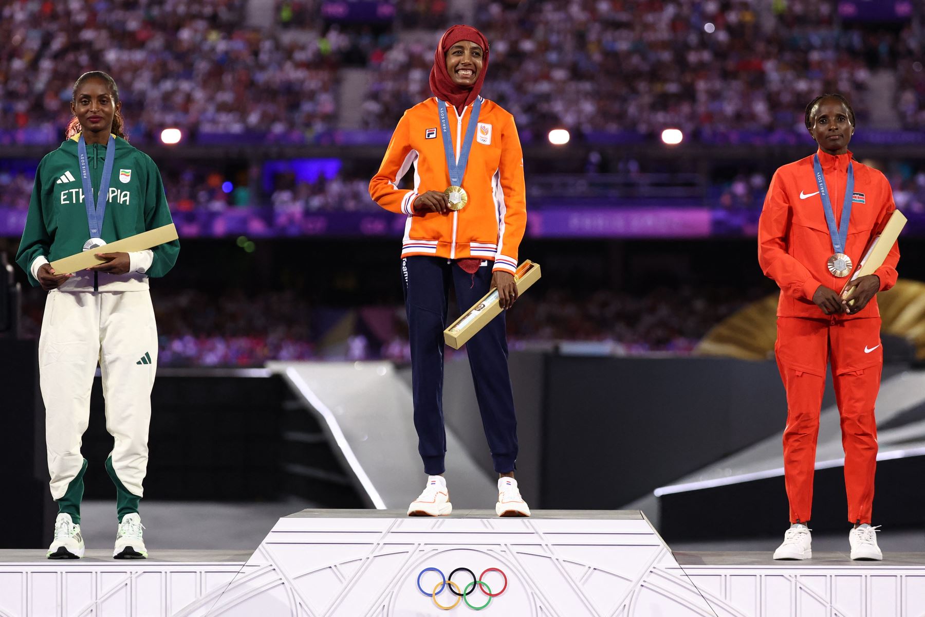 Tigst Assefa, medallista de plata de Etiopía, Sifan Hassan, medallista de oro de Holanda, y Hellen Obiri, medallista de bronce de Kenia, posan durante la ceremonia del podio del maratón femenino del evento de atletismo durante la ceremonia de clausura de los Juegos Olímpicos de París 2024 en el Stade de France. en Saint-Denis, en las afueras de París.
Foto: AFP