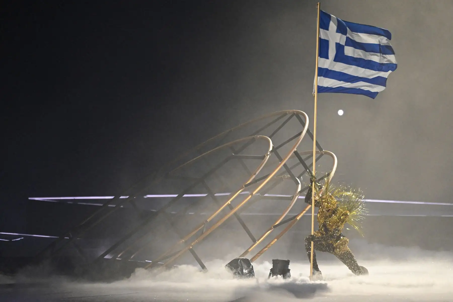 Un artista sostiene la bandera de Grecia mientras participa durante la ceremonia de clausura de los Juegos Olímpicos de París 2024 en el Stade de France, en Saint-Denis, en las afueras de París.
Foto: AFP