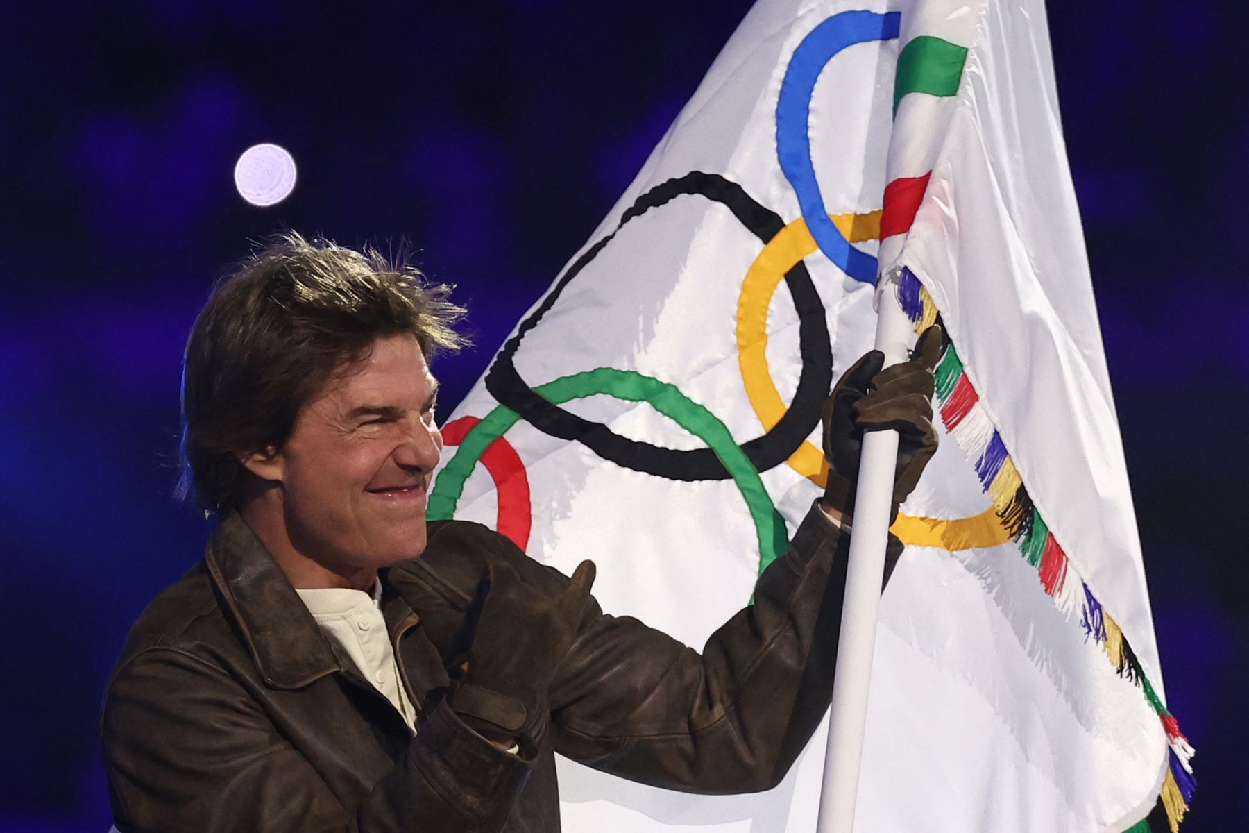 El actor estadounidense Tom Cruise ondea la bandera olímpica durante la ceremonia de clausura de los Juegos Olímpicos de París 2024 en el Stade de France, en Saint-Denis, en las afueras de París.
Foto: AFP