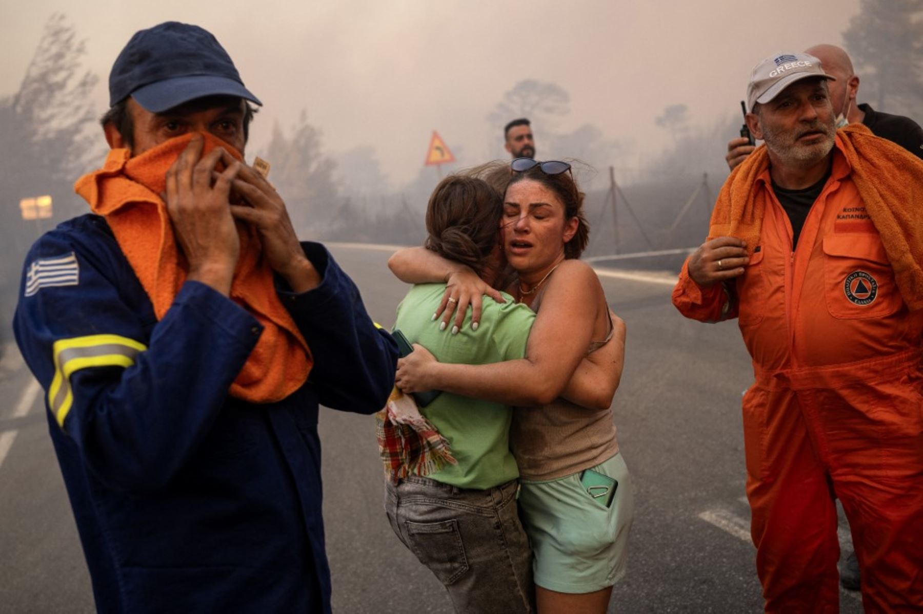 Mujeres se abrazan tras ser rescatadas durante un incendio forestal en Varnavas, al norte de Atenas. Foto: AFP