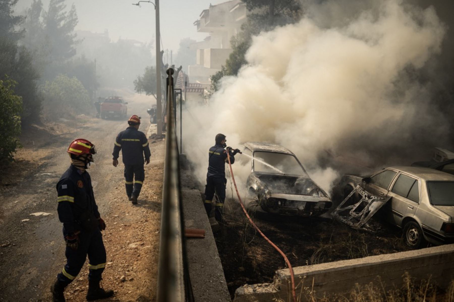 Un bombero rocía agua a un coche en llamas durante un incendio forestal en Dione. Foto: AFP