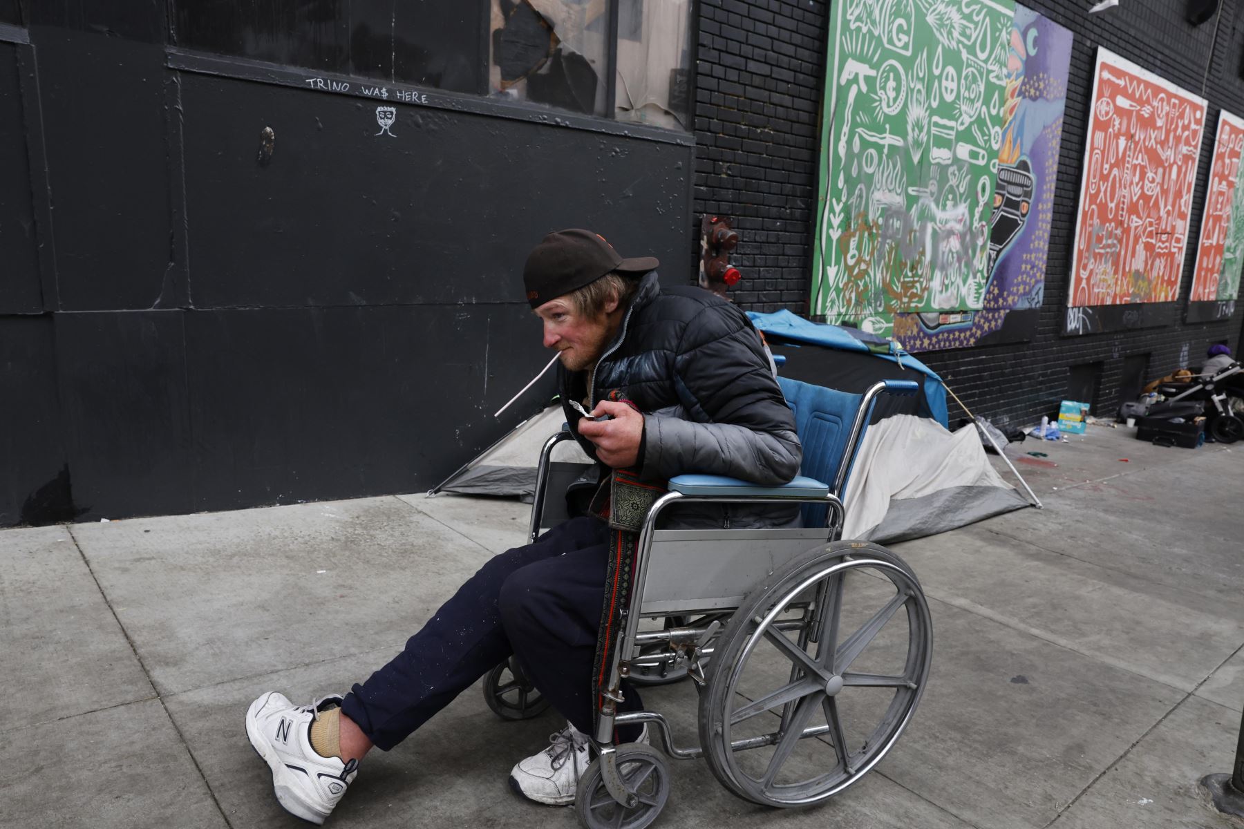 Una persona en silla de ruedas recoge sus pertenencias antes de que el equipo de Obras Públicas de San Francisco y el Departamento de Bomberos y paramédicos despejen un campamento de personas sin hogar en San Francisco, California, EE.UU., 12 de agosto de 2024. Foto: EFE