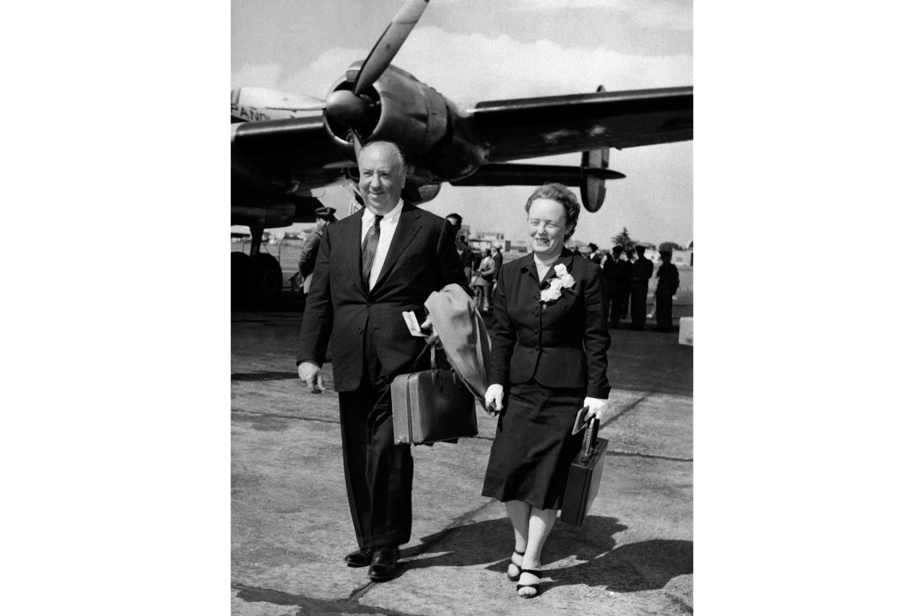 El director de cine británico Alfred Hitchcock y su esposa Alma Reville caminan cerca del avión después de su llegada a Roma, Italia, en junio de 1956.
Foto: AFP