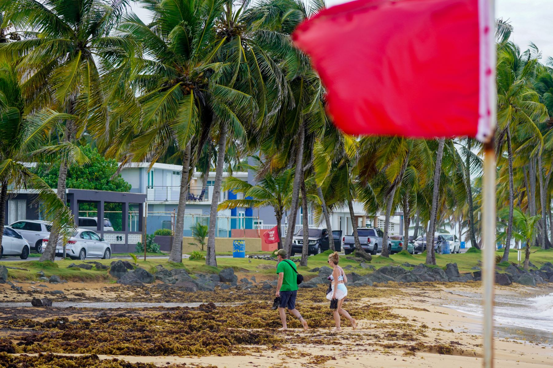 La gente abandona la playa mientras se iza una bandera roja, que indica condiciones peligrosas para nadar, en Luquillo, Puerto Rico, el 13 de agosto de 2024, a medida que se acerca la tormenta tropical Ernesto. Foto: AFP