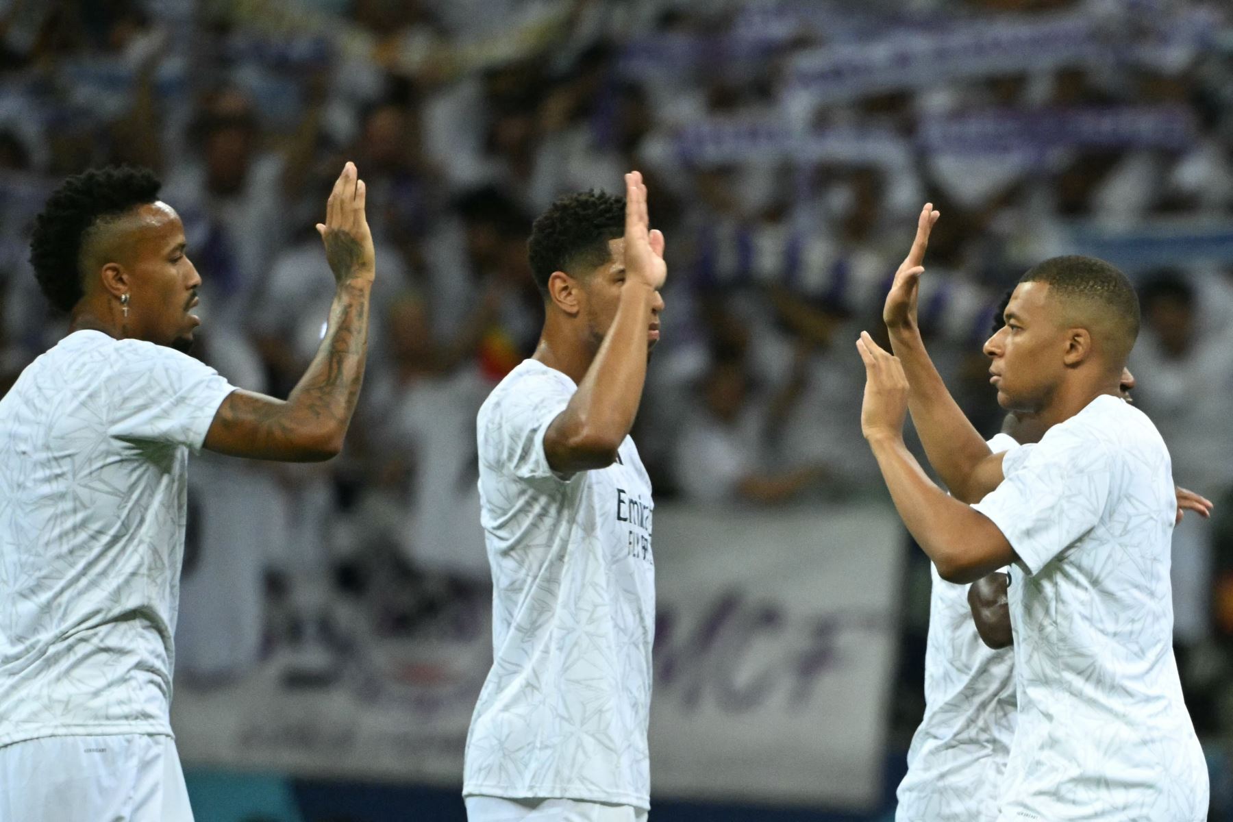 El delantero francés del Real Madrid  Kylian Mbappe choca los cinco con el defensor francés del Real Madrid Aurelien Tchouameni y el defensor brasileño del Real Madrid  Eder Militao por delante del partido de fútbol de la Supercopa de la UEFA entre el Real Madrid y el Atalanta BC en Varsovia. AFP