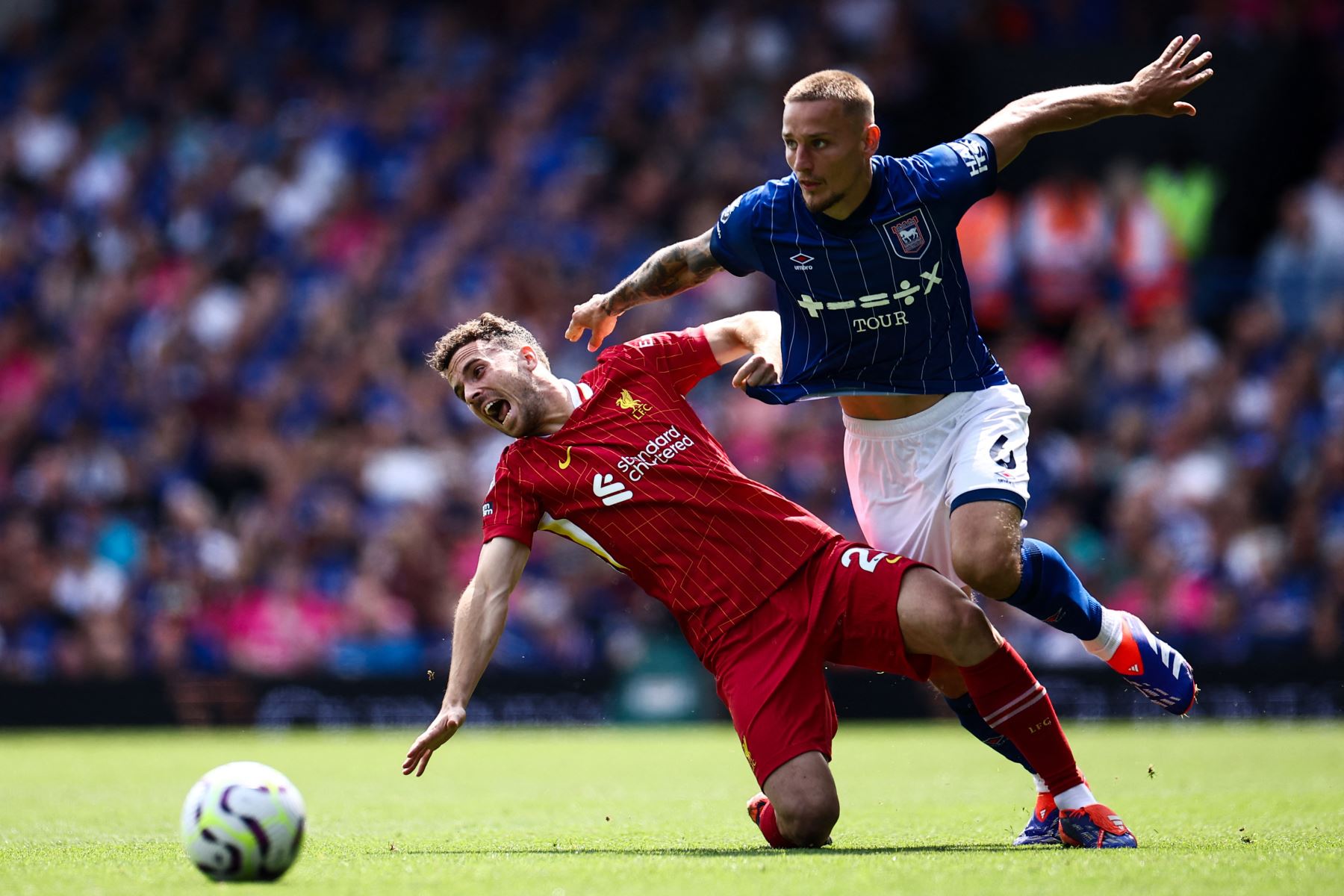 El delantero portugués de Liverpool  Diogo Jota  lucha por el balón con el defensor inglés de Ipswich Town  Luke Woolfenden durante el partido de fútbol de la Liga Premier inglesa entre Ipswich Town y Liverpool en Portman Road en Ipswich. AFP