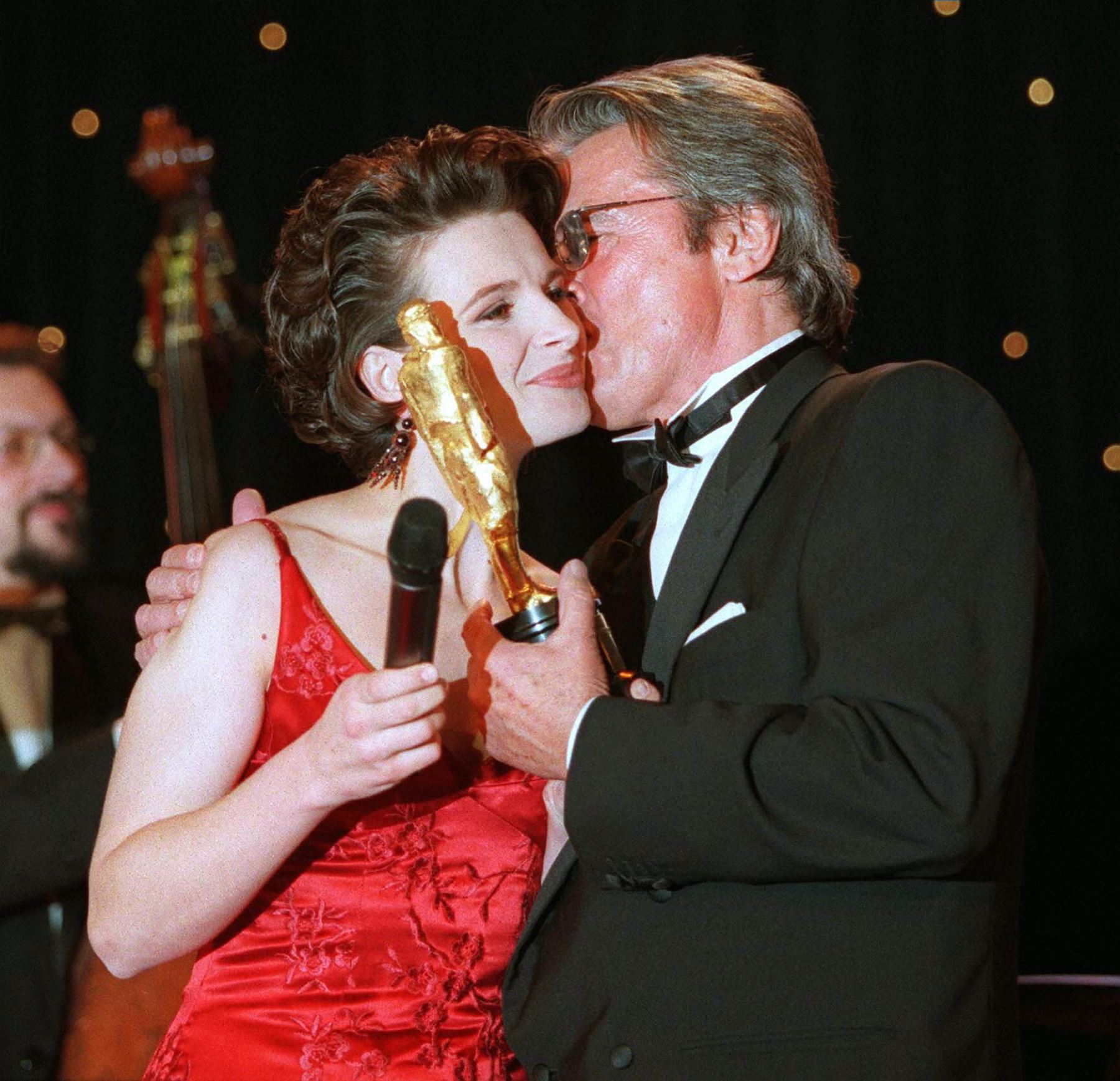 La actriz francesa Juliette Binoche un premio europeo de cine Rudolph Valentino de oro  y un beso en la mejilla del actor francés Alain Delon durante la ceremonia de entrega de premios en el Louvre de París. AFP