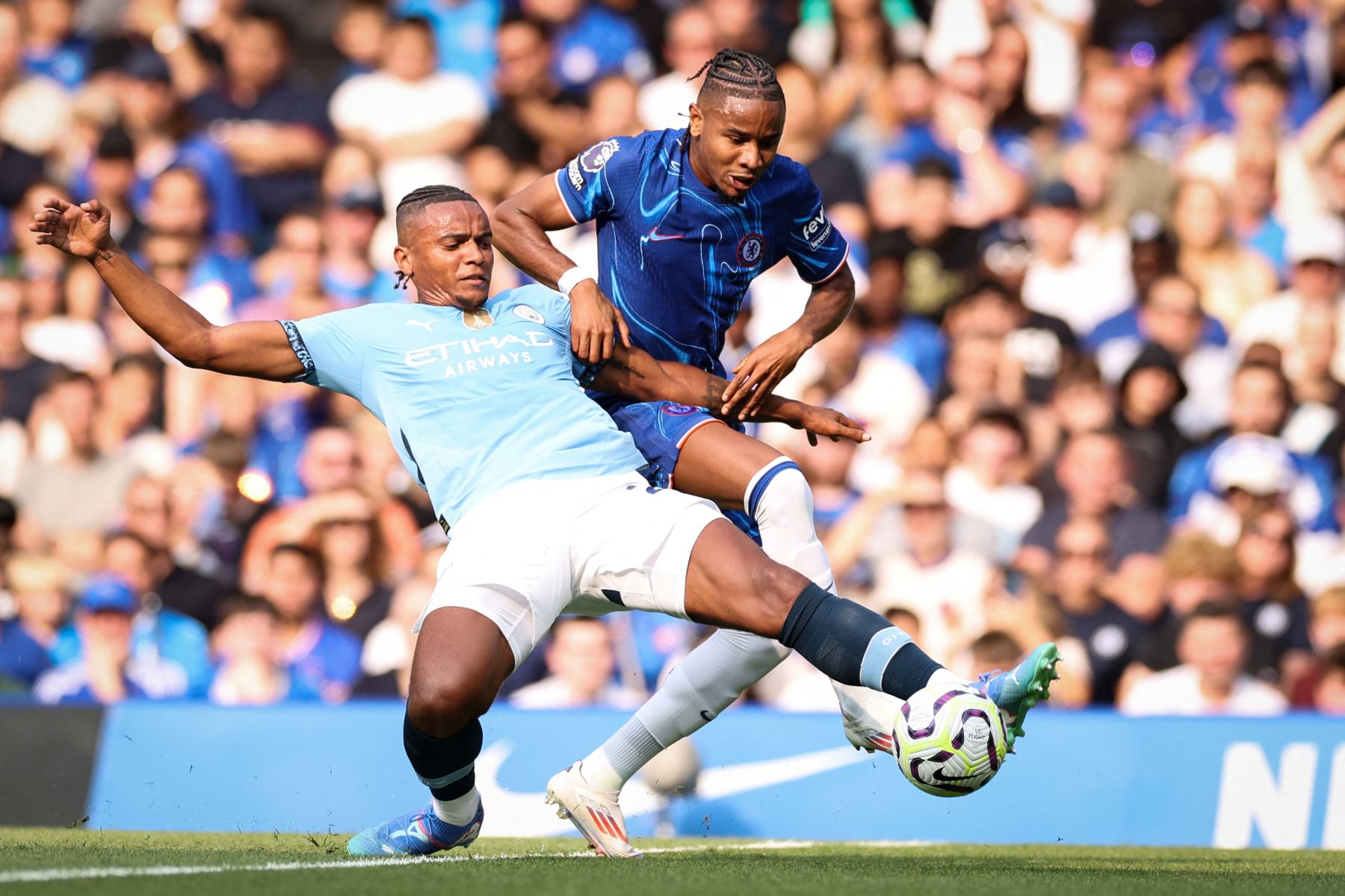 El defensor suizo del Manchester City  Manuel Akanji es abordado por el delantero francés del Chelsea Christopher Nkunku mientras luchan durante el partido de fútbol de la Liga Premier inglesa entre Chelsea y Manchester City. AFP