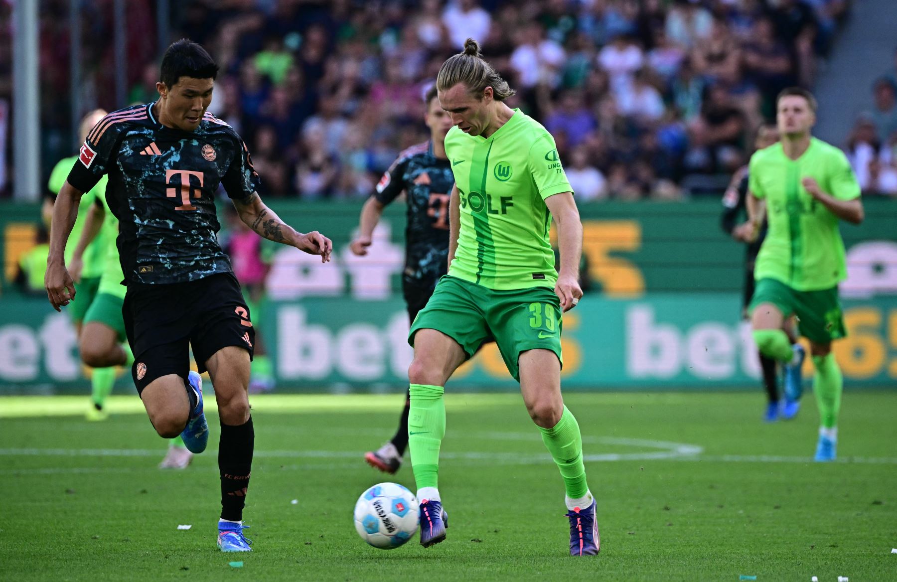 El defensor surcoreano del Bayern Munich  Kim†Min-Jae y el centrocampista austriaco del Wolfsburg  Patrick Wimmer compiten por el balón durante el partido de fútbol de la primera división alemana de la Bundesliga entre el VfL Wolfsburg y el FC Bayern Munich en Wolfsburg. AFP