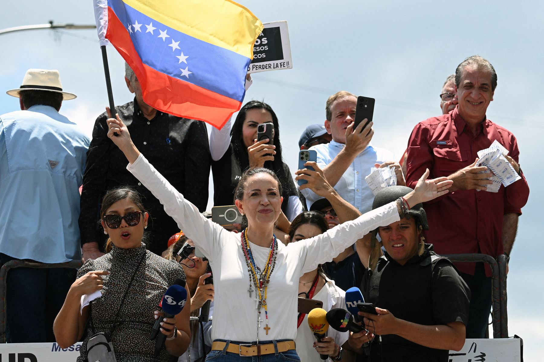 María Corina Machado sostiene una bandera venezolana encima de un camión durante una protesta convocada por la oposición para que se reconozca la "victoria" electoral. Foto: AFP