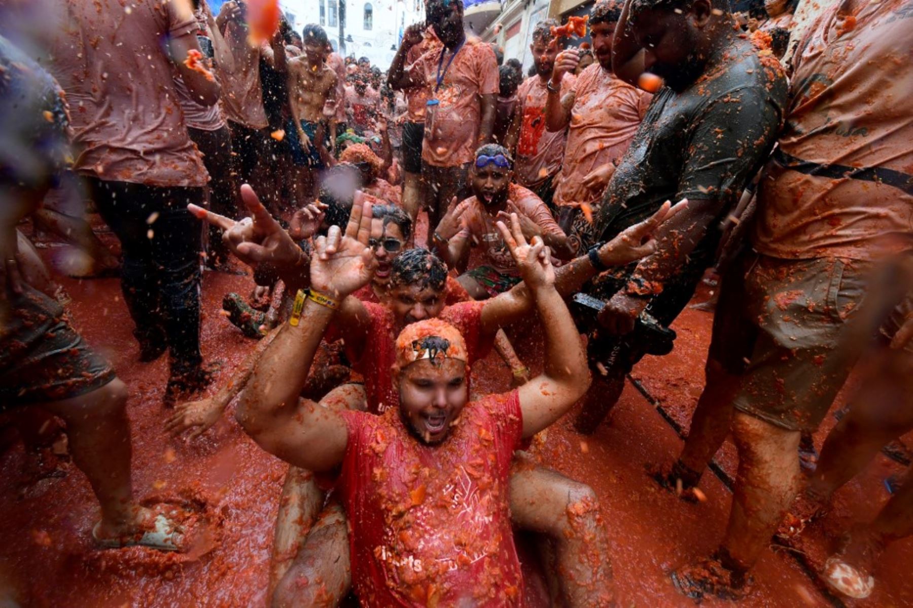 Unas 15.000 personas participaron en esta batalla en que se usaron 130 toneladas de tomates maduros como munición, según datos del ayuntamiento, y que tiñó de rojo las calles y las ropas de los participantes, que suelen vestirse de blanco. Foto: AFP