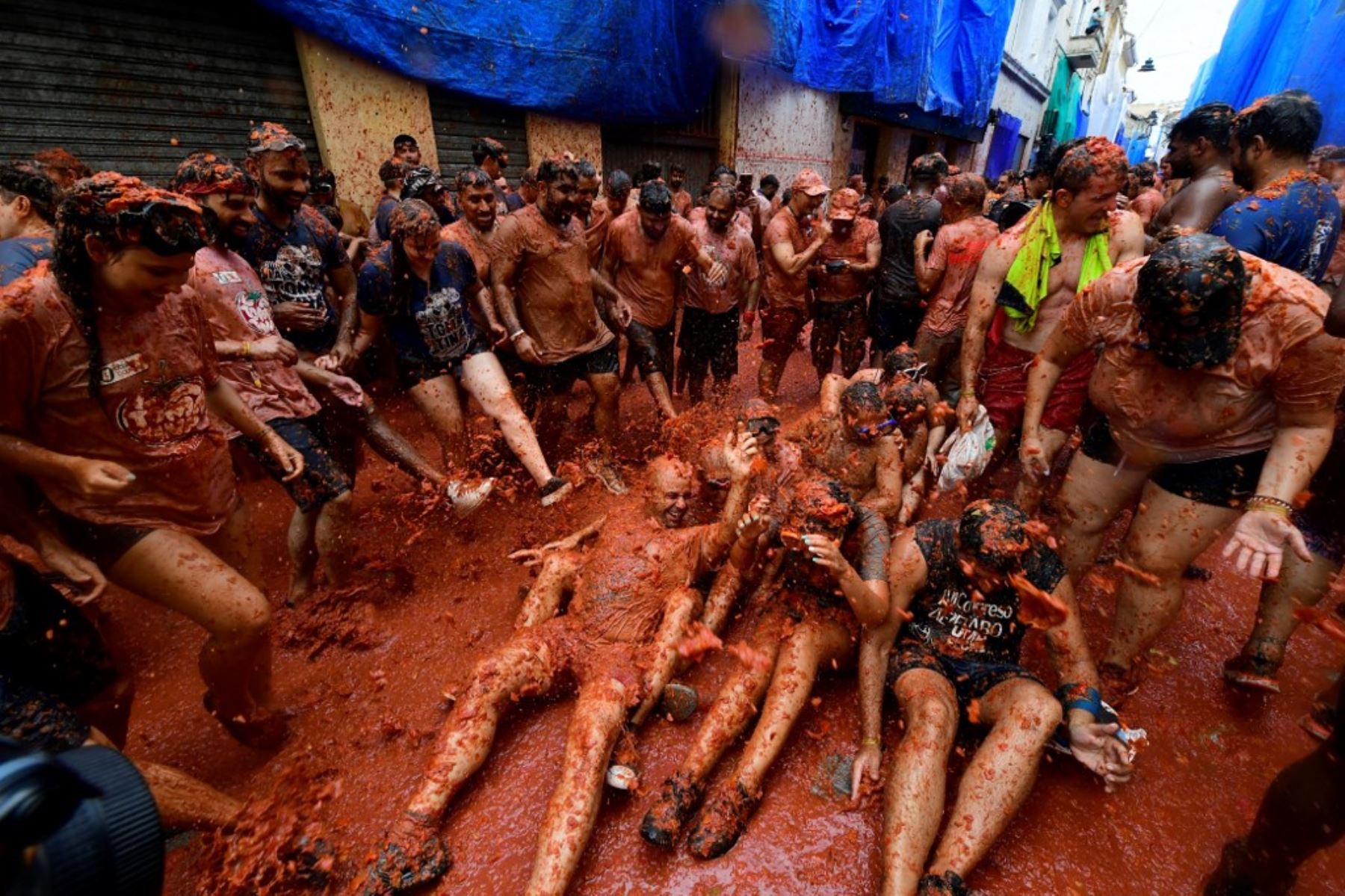 Unas 15.000 personas participaron en esta batalla en que se usaron 130 toneladas de tomates maduros como munición, según datos del ayuntamiento, y que tiñó de rojo las calles y las ropas de los participantes, que suelen vestirse de blanco. Foto: AFP