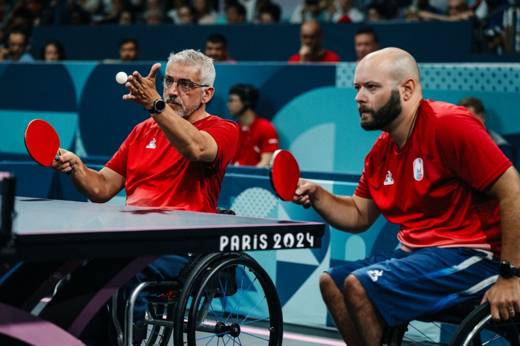 El francés Emeric Martin, sirve una pelota junto al francés Maxime Thamas durante su partido doble de tenis de mesa masculino de octavos de final (clase 4-3) entre Australia y Francia en los Juegos Paralímpicos París 2024 . Foto: AFP