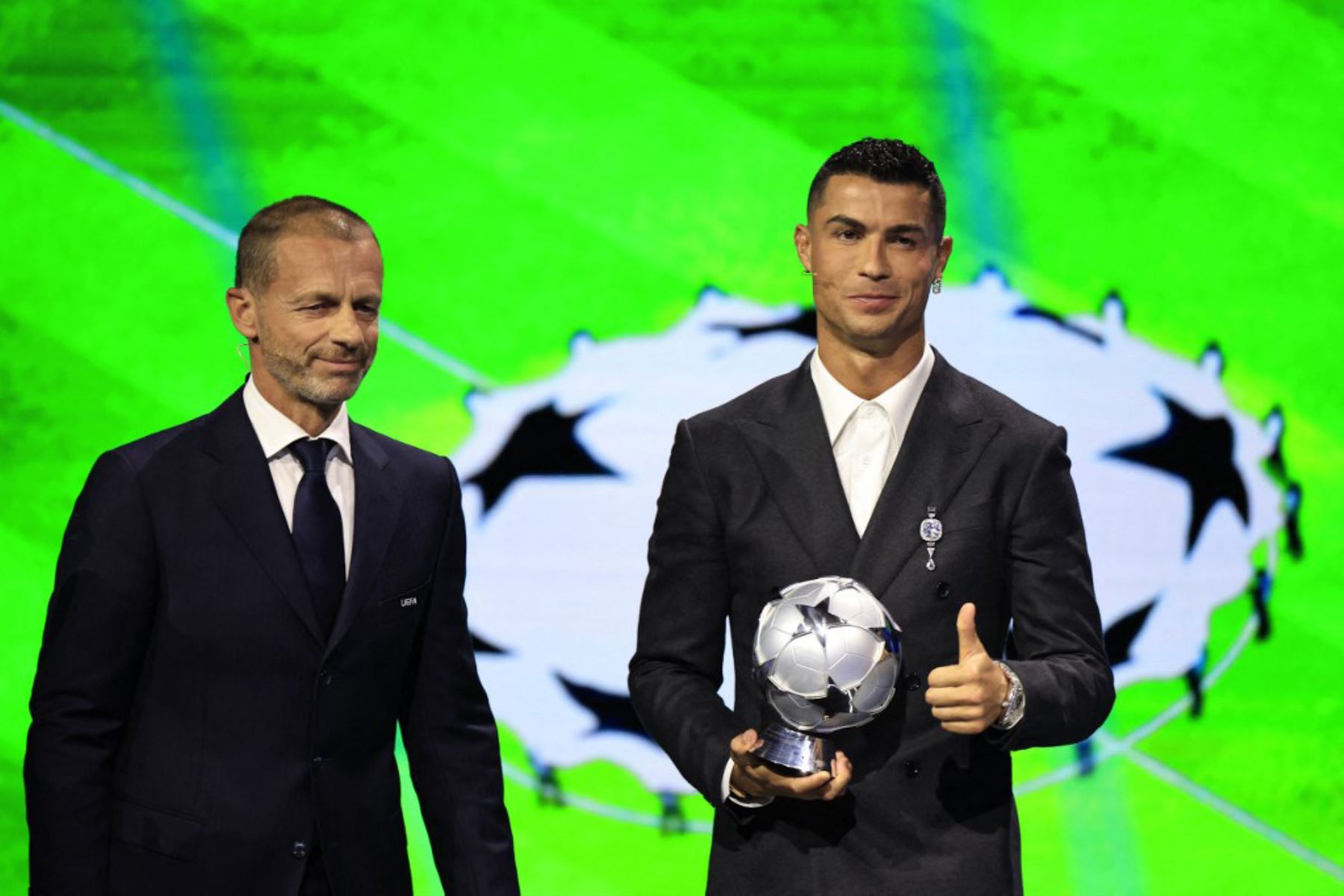 El jugador de la selección portuguesa y delantero del Al-Nassr saudí Cristiano Ronaldo, recibe el premio al goleador histórico de la Liga de Campeones de la UEFA de manos del presidente de la UEFA, Aleksander Ceferin, durante la ceremonia del sorteo de la fase de grupos de la Liga de Campeones de la UEFA 2024-2025. Foto: AFP