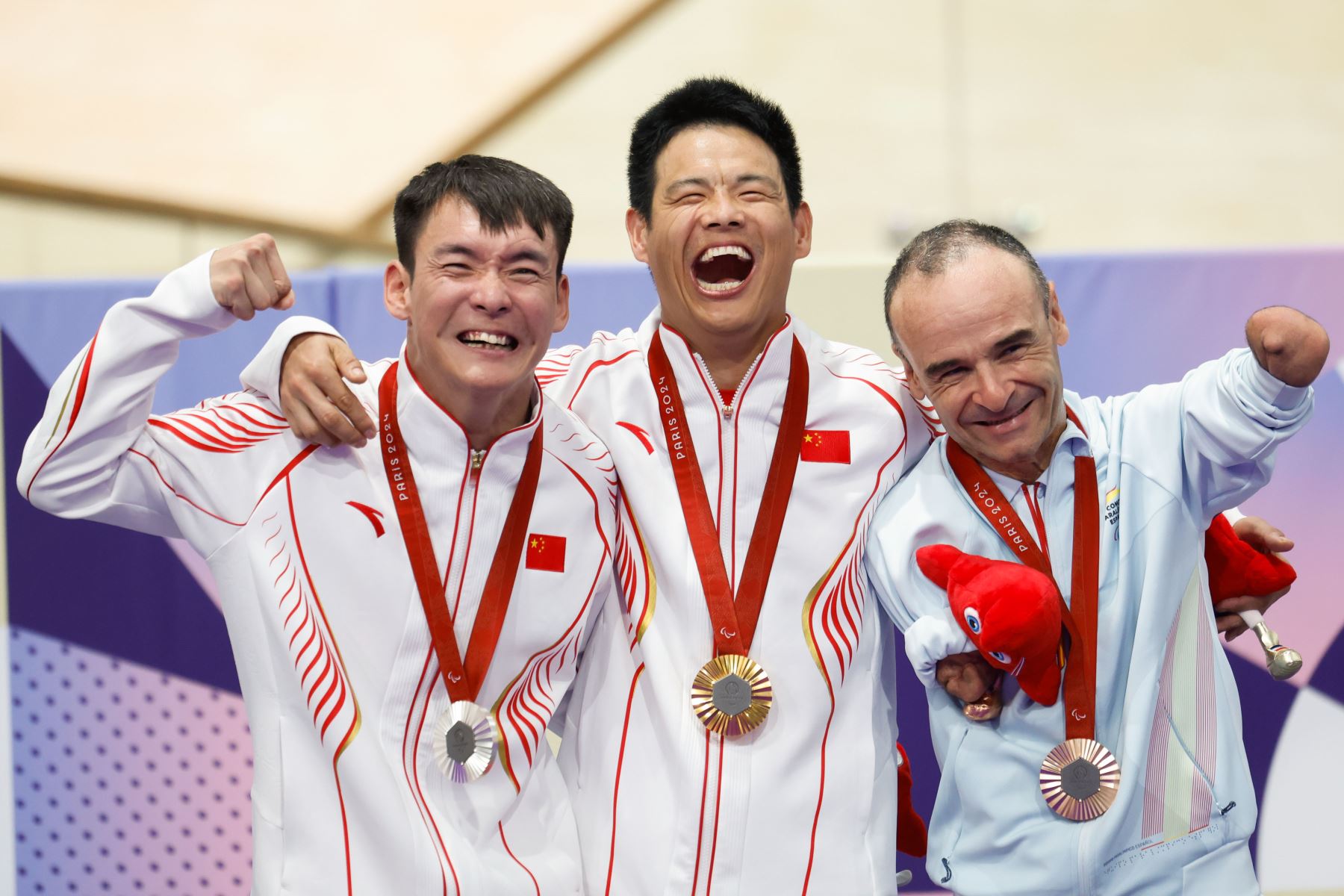 Los ciclistas chinos Li Zhangyu (oro) y Weicong Liang (plata), y el español Ricardo Ten (bronce) posan con las medallas tras la prueba de persecución de 3000 metros, este jueves en los Juegos Paralímpicos París 2024 en Francia. Foto: EFE