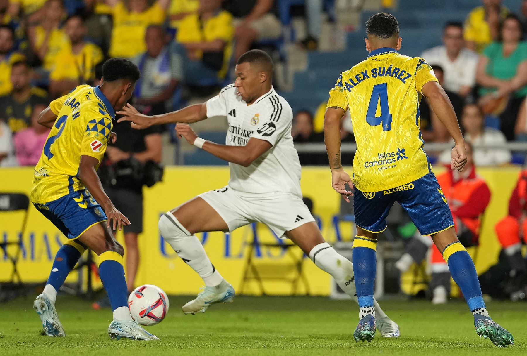 El delantero francés del Real Madrid  Kylian Mbappé lucha por el balón con el defensor español de Las Palmas  Marvin Park y el defensor español de Las Palmas  Alex Suárez durante el partido de fútbol de la liga española entre la UD Las Palmas y el Real Madrid CF. Foto: AFP