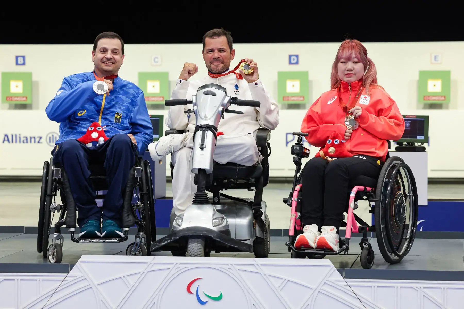 El medallista de plata Alexandre Augusto de Brasil, el medallista de oro Tanguy De La Forest de Francia y el medallista de bronce Mika Mizuta de Japón asisten a la ceremonia de victoria del evento R5 mixto 10m Air Rifle Prone SH2 de los Juegos Paralímpicos de París 2024.  Foto:ANDINA/AFP
