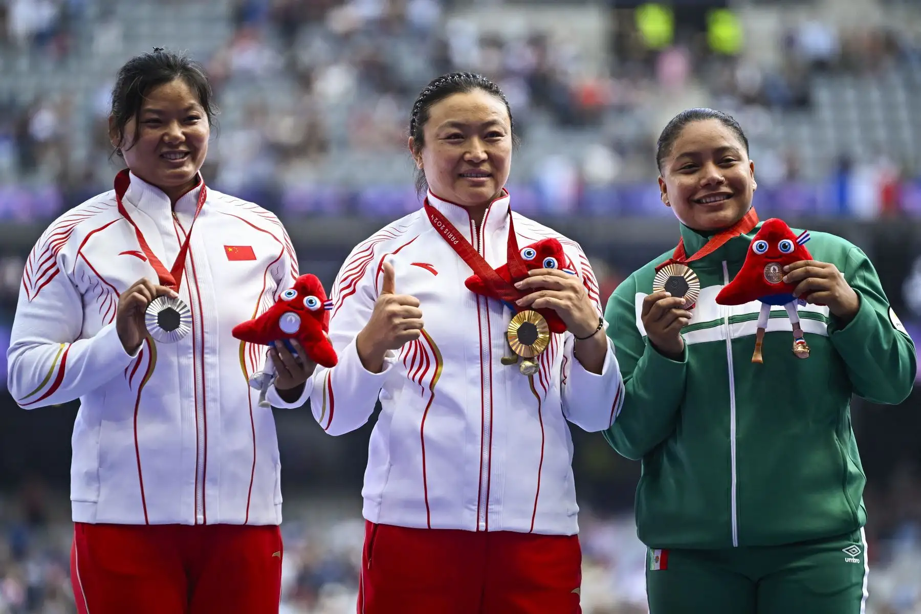 Juan Yao, medallista de plata de China, Yue Yang, medallista de oro de China, y Osiris Aneth Machado Plata, medallista de bronce de México, posan en el podio del lanzamiento de disco femenino - F64 durante los Juegos Paralímpicos de París 2024.
Foto: ANDINA/AFP