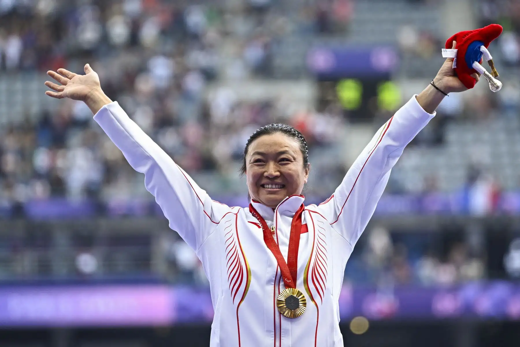 La medallista de oro china Yue Yang posa en el podio del lanzamiento de disco femenino - F64 durante los Juegos Paralímpicos de París 2024. Foto: ANDINA/AFP