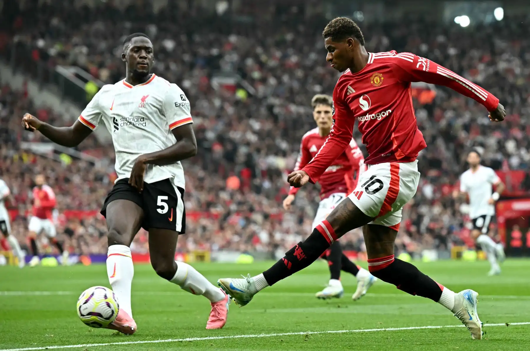 El delantero inglés del Manchester United Marcus Rashford  intenta pasar el balón por encima del defensor francés del Liverpool Ibrahima Konate durante el partido de fútbol de la Premier League inglesa entre el Manchester United y el Liverpool.
Foto: ANDINA/AFP