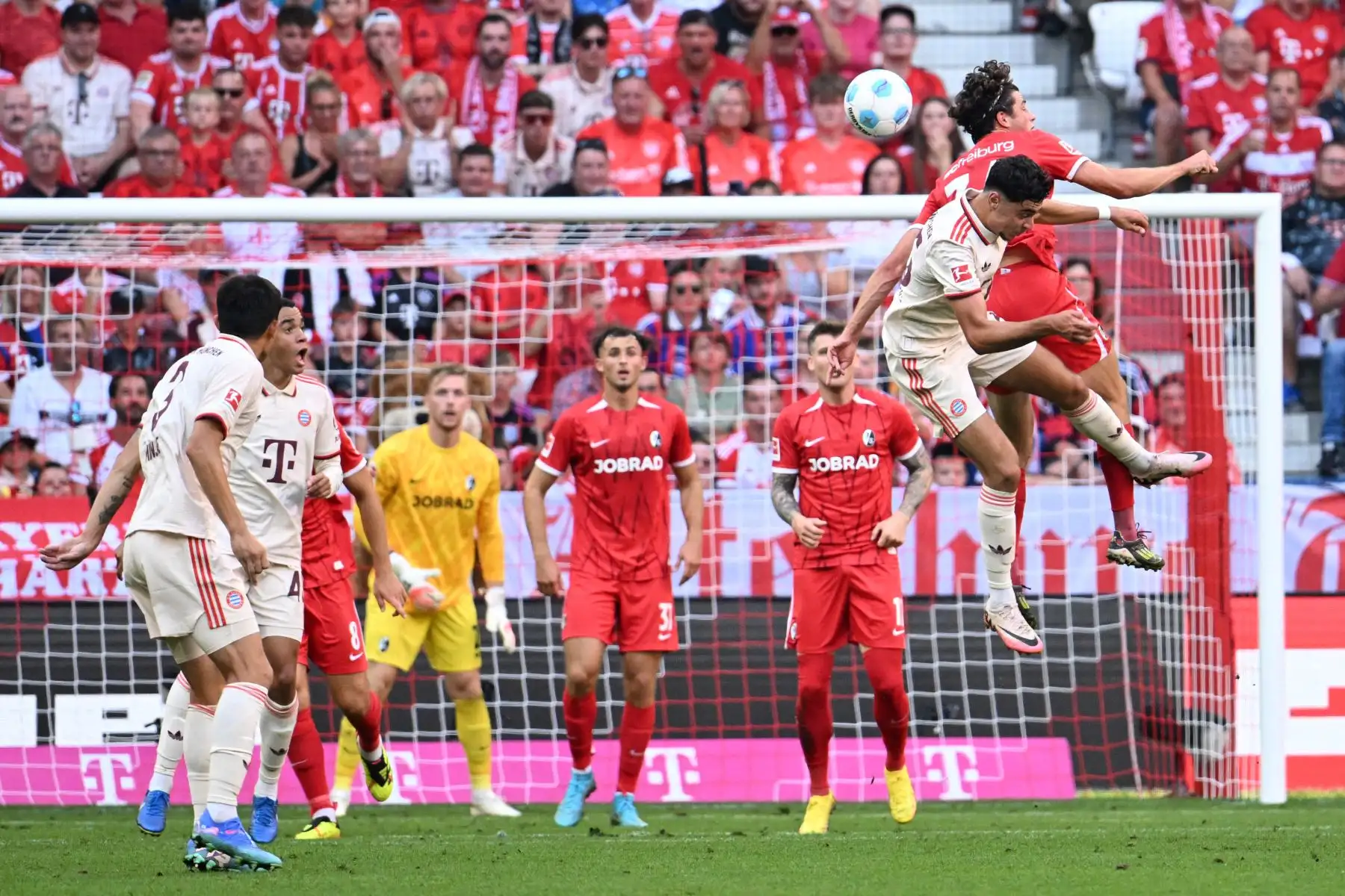 El centrocampista alemán del Bayern Munich  Aleksandar Pavlovic  y el centrocampista alemán del Friburgo Merlin Roehl saltan por el balón durante el partido de fútbol de la primera división alemana Bundesliga entre el FC Bayern Munich y el SC Freiburg. Foto: ANDINA/ AFP