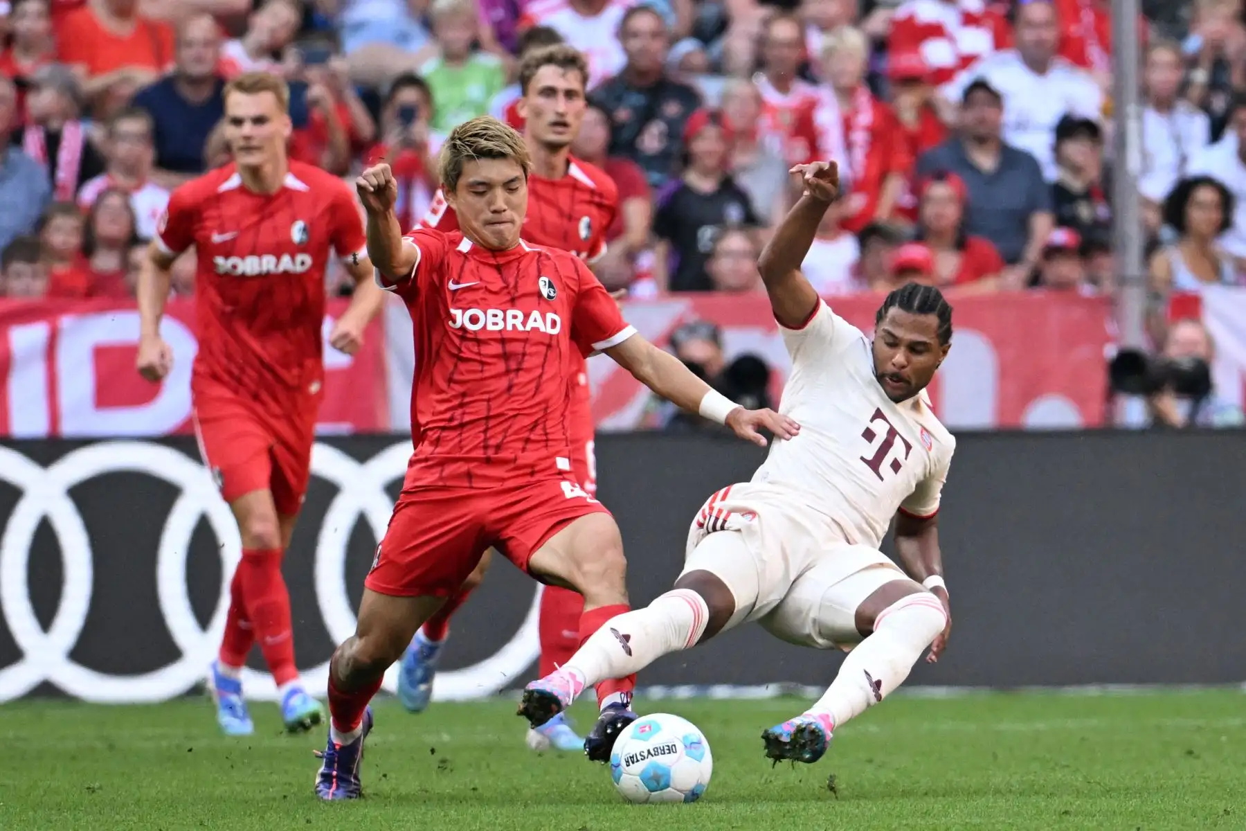 El delantero japonés del Friburgo, Ritsu Doan, y el delantero alemán del Bayern Múnich, Serge Gnabry, disputan el balón durante el partido de fútbol de la primera división alemana, la Bundesliga, entre el FC Bayern Múnich y el SC Friburgo. Foto: ANDINA/ AFP