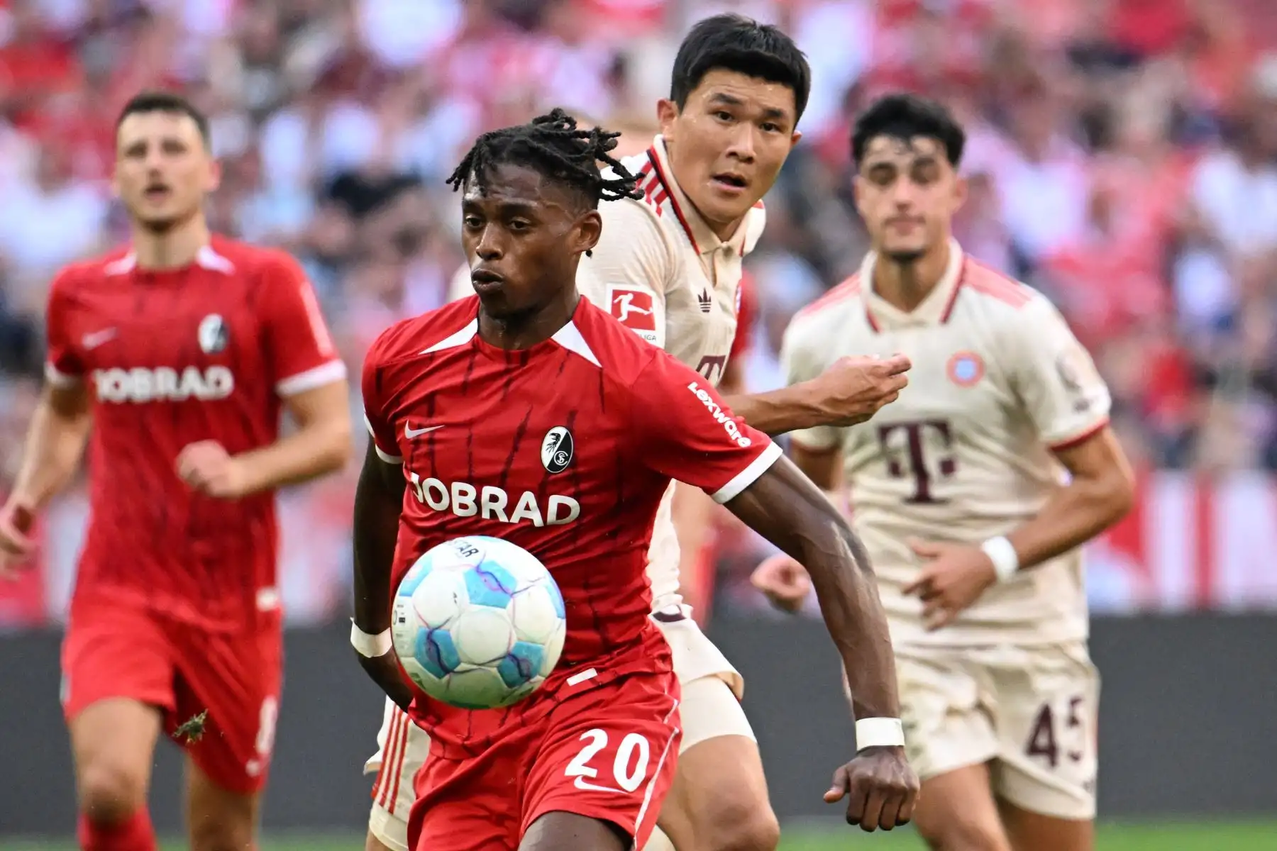 El delantero austríaco  del Friburgo, Junior Adamu, y el defensa surcoreano del Bayern Múnich, Kim Min-Jae, compiten por el balón durante el partido de fútbol de la primera división alemana, la Bundesliga, entre el FC Bayern Múnich y el SC Freiburg. Foto: ANDINA/AFP