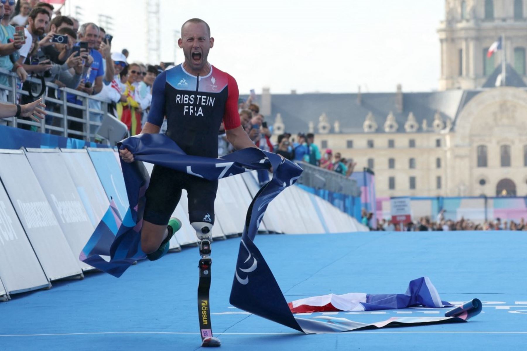 El francés Jules Ribstein celebra al cruzar la línea de meta y ganar el evento de paratriatlón PTS2 masculino en los Juegos Paralímpicos de París 2024 en el Puente Alexandre III el 2 de septiembre de 2024. Foto: AFP