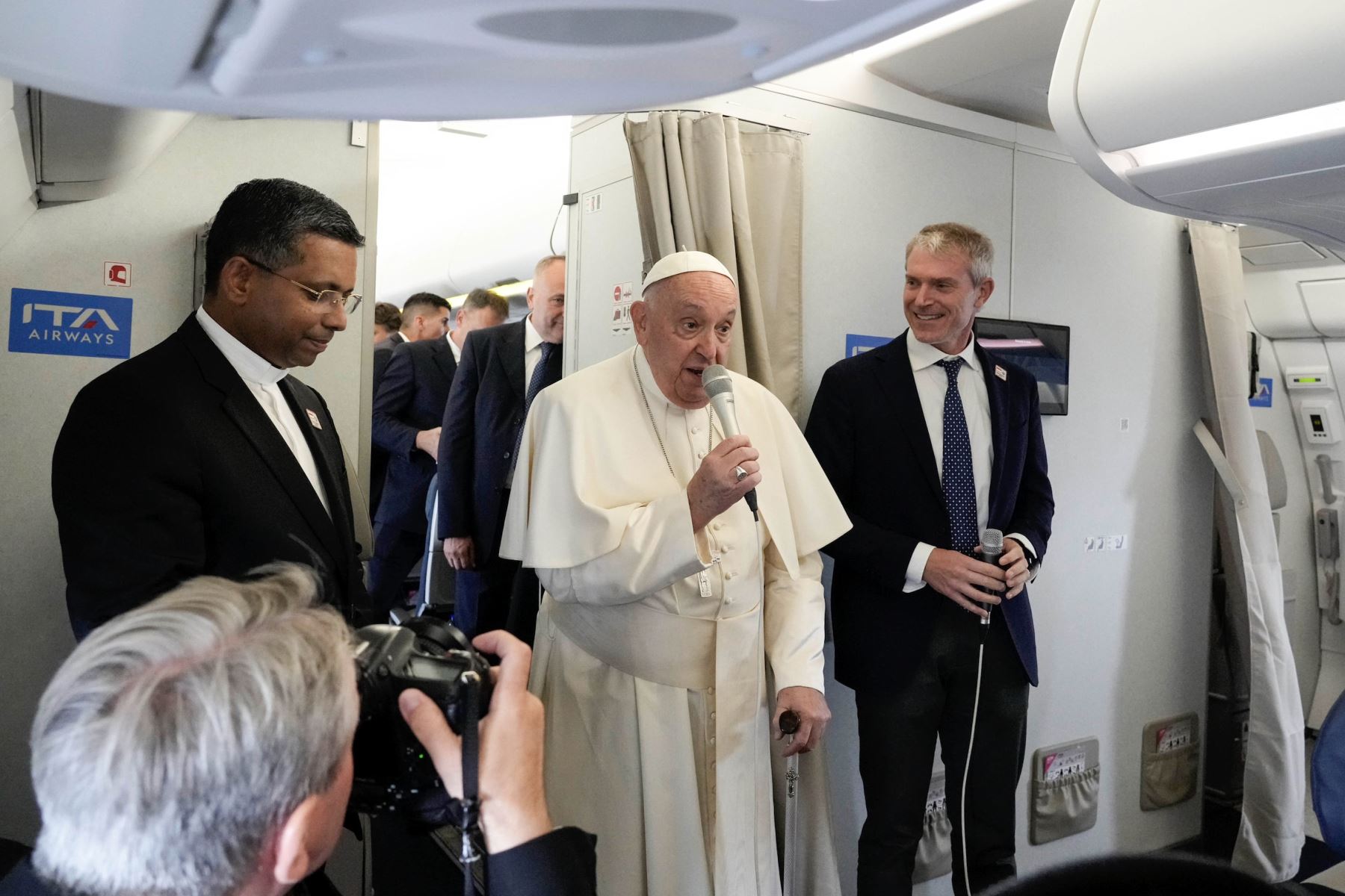 El papa Francisco, flanqueado por su portavoz, Matteo Bruni, habla con periodistas a bordo del vuelo con destino a Yakarta, la primera parada de su viaje apostólico al Sudeste Asiático. Foto: EFE