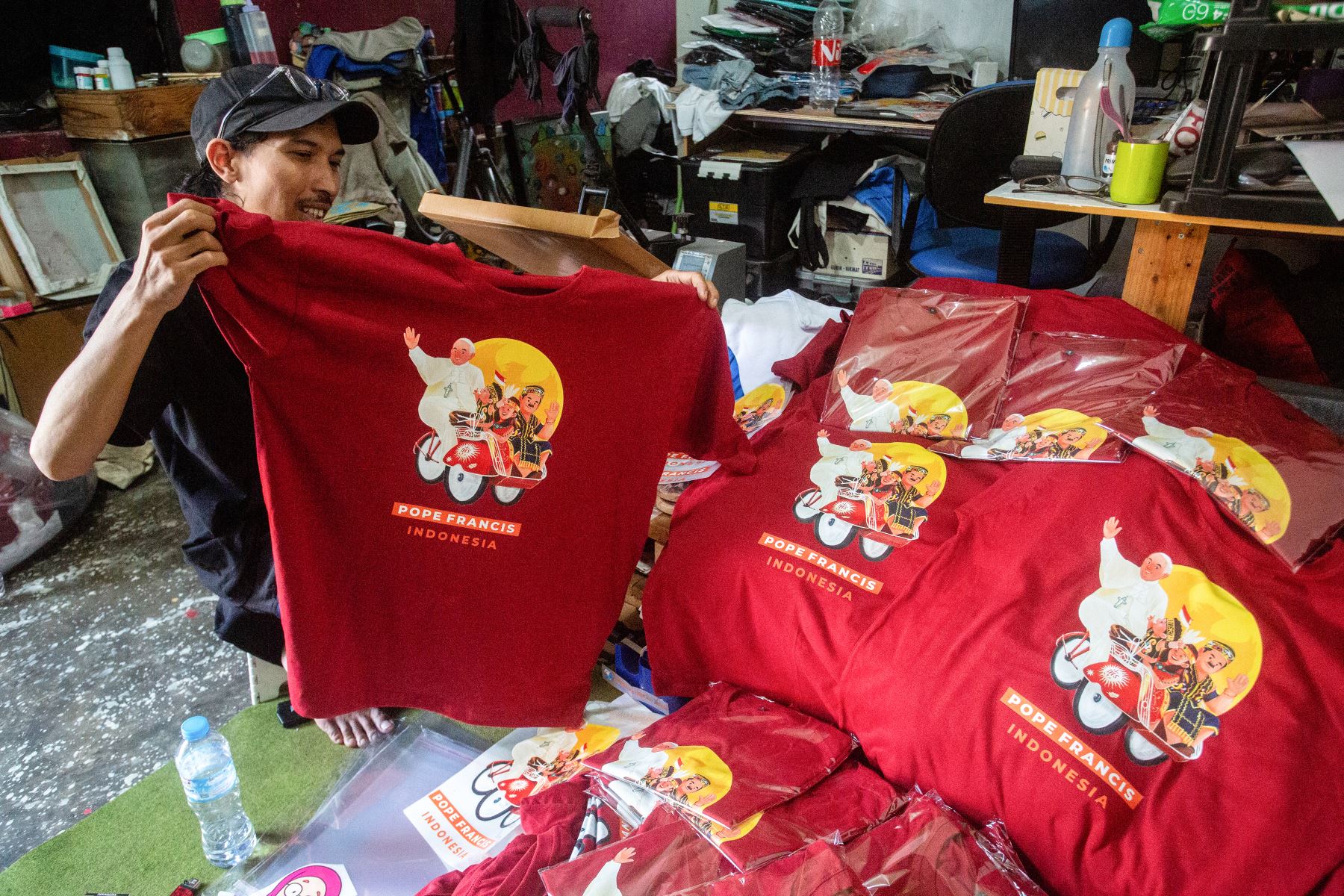 Un hombre confecciona camisetas encargadas por un grupo que asistirá a la misa del Papa Francisco en el estadio Gelora Bung Karno de Yakarta, en su taller de Yogyakarta.
Foto: AFP