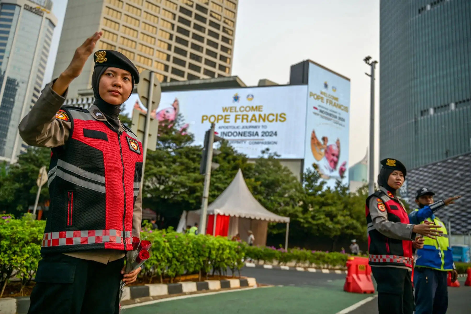 La policía indonesia dirige el tráfico junto a carteles que muestran un mensaje de bienvenida para el Papa Francisco en Yakarta.
Foto: AFP