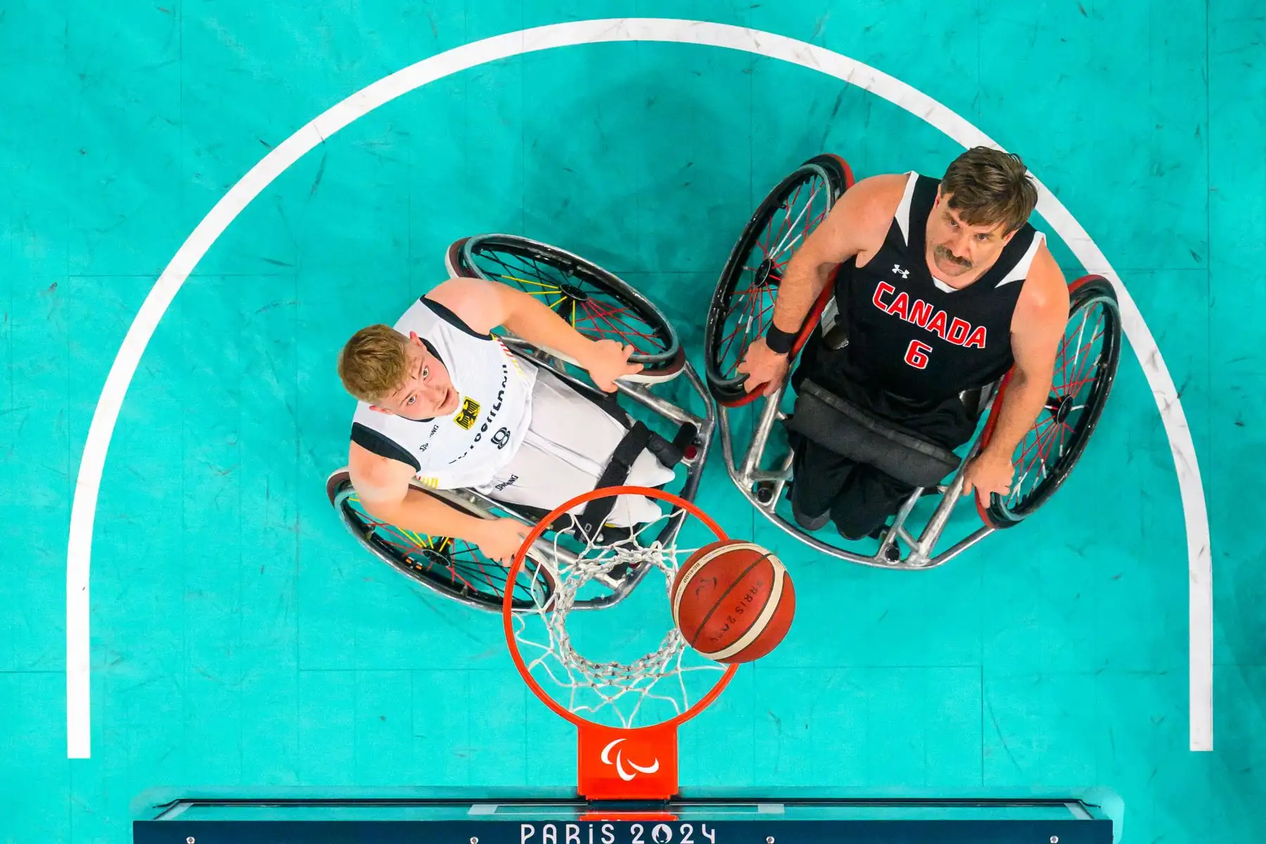 Tobias Hell de Alemania (izq.) y Robert Hedges de Canadá (der.) compitiendo en el partido n.° 22 del Grupo A de la ronda preliminar de baloncesto en silla de ruedas masculino, durante los Juegos Paralímpicos de París 2024 en el Bercy Arena de París. Foto: AFP