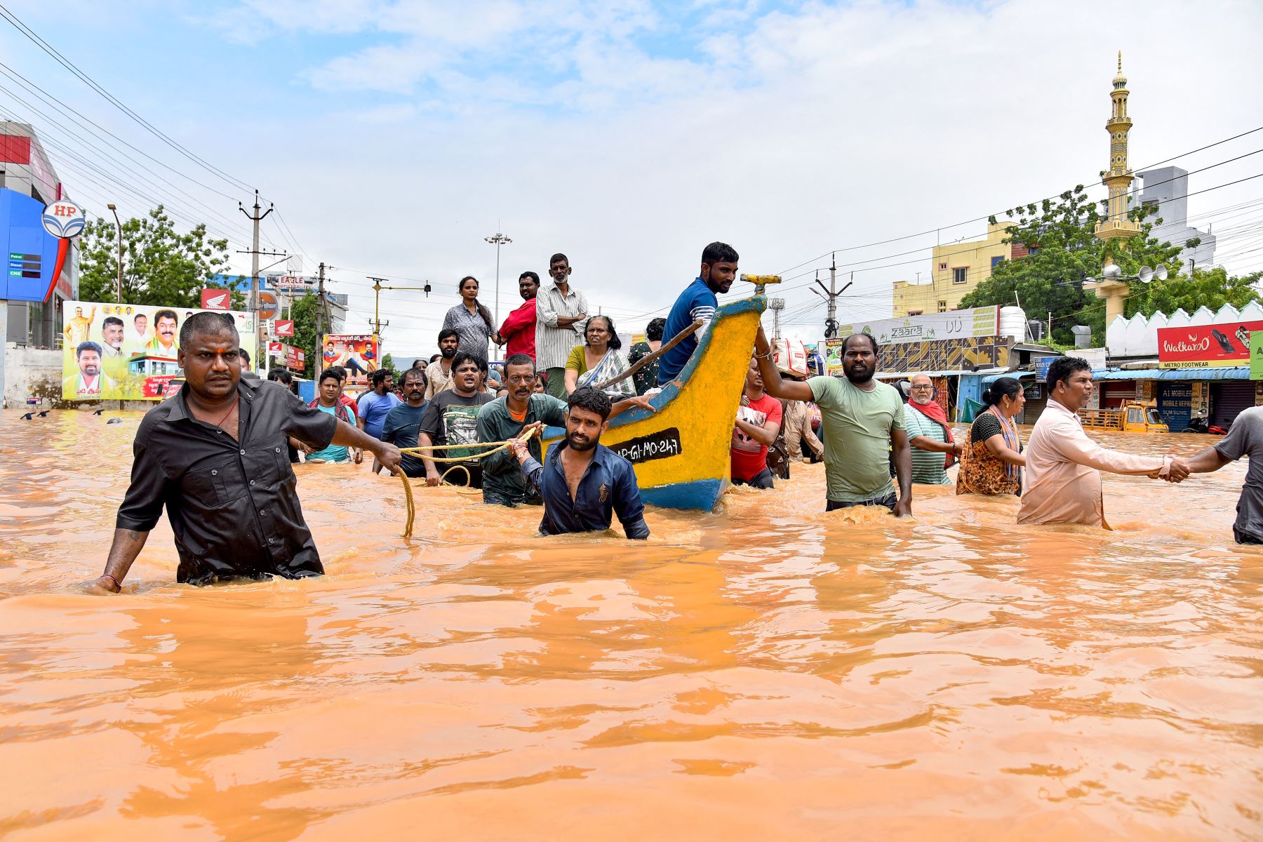 La gente viaja en bote mientras otros caminan por una calle inundada después de las fuertes lluvias monzónicas, en Vijayawada. Las intensas lluvias monzónicas y las inundaciones en los estados del sur de la India han matado al menos a 25 personas, y miles han sido rescatadas y llevadas a campos de socorro.
Foto: AFP