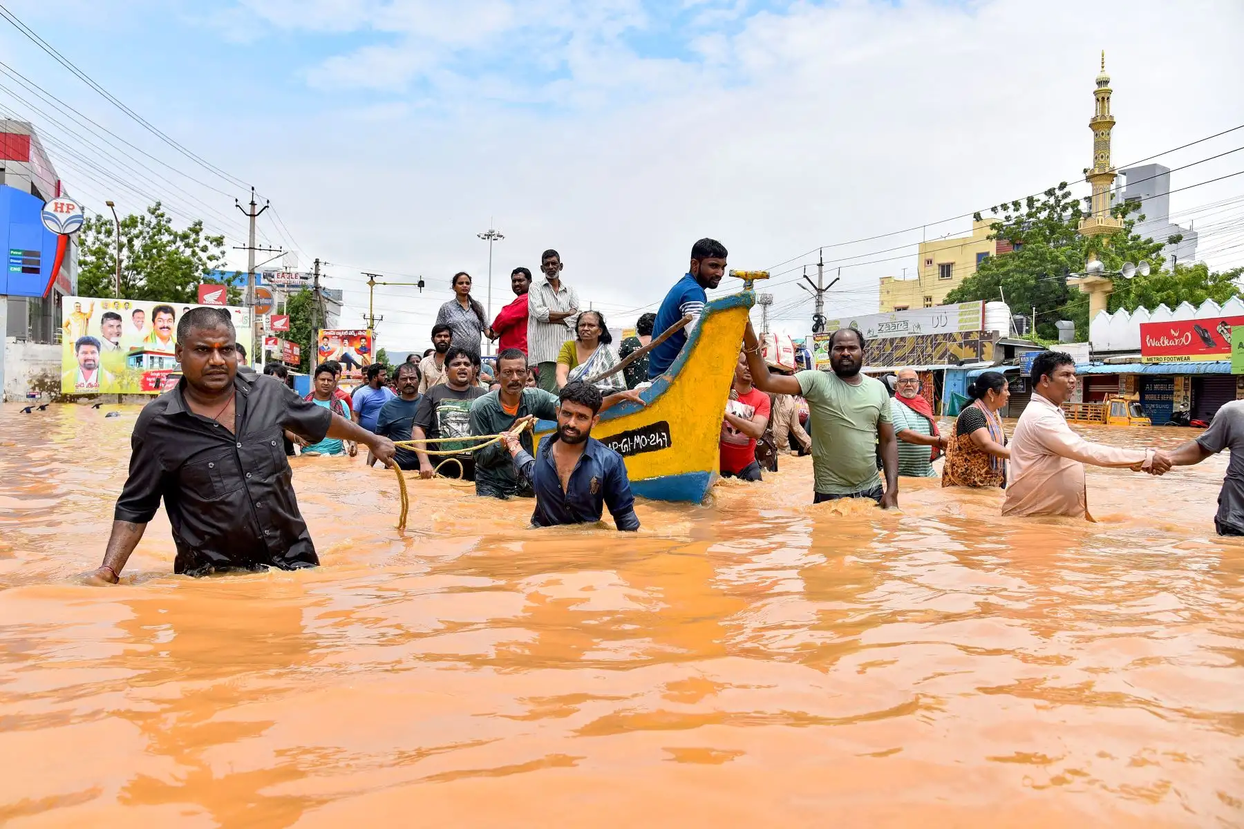 La gente viaja en bote mientras otros caminan por una calle inundada después de las fuertes lluvias monzónicas, en Vijayawada. Las intensas lluvias monzónicas y las inundaciones en los estados del sur de la India han matado al menos a 25 personas, y miles han sido rescatadas y llevadas a campos de socorro.
Foto: AFP
