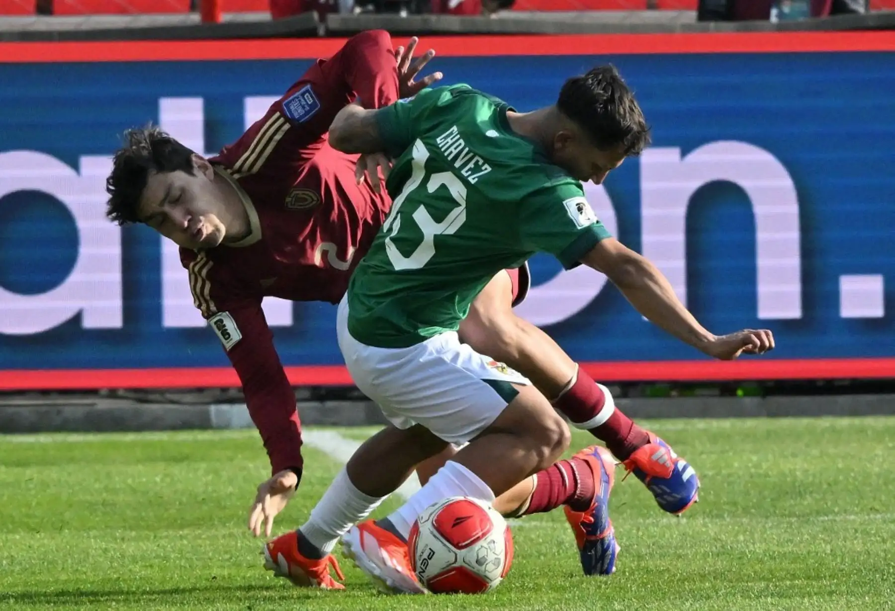 El mediocampista boliviano Lucas Chávez (frente) y el defensa venezolano Nahuel Ferraresi luchan por el balón durante el partido de fútbol de las eliminatorias sudamericanas de la Copa Mundial de la FIFA 2026 entre Bolivia y Venezuela, en el estadio Municipal, en El Alto, Bolivia. Foto: AFP