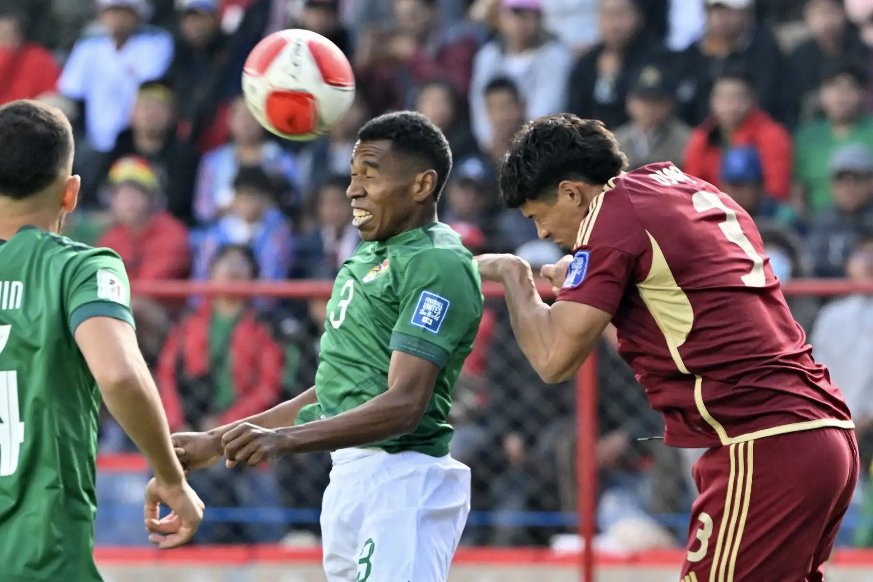 El defensa boliviano Diego Medina (C) y el defensa venezolano Yordan Osorio saltan para cabecear el balón durante el partido de fútbol de las eliminatorias sudamericanas de la Copa Mundial de la FIFA 2026 entre Bolivia y Venezuela. Foto: AFP