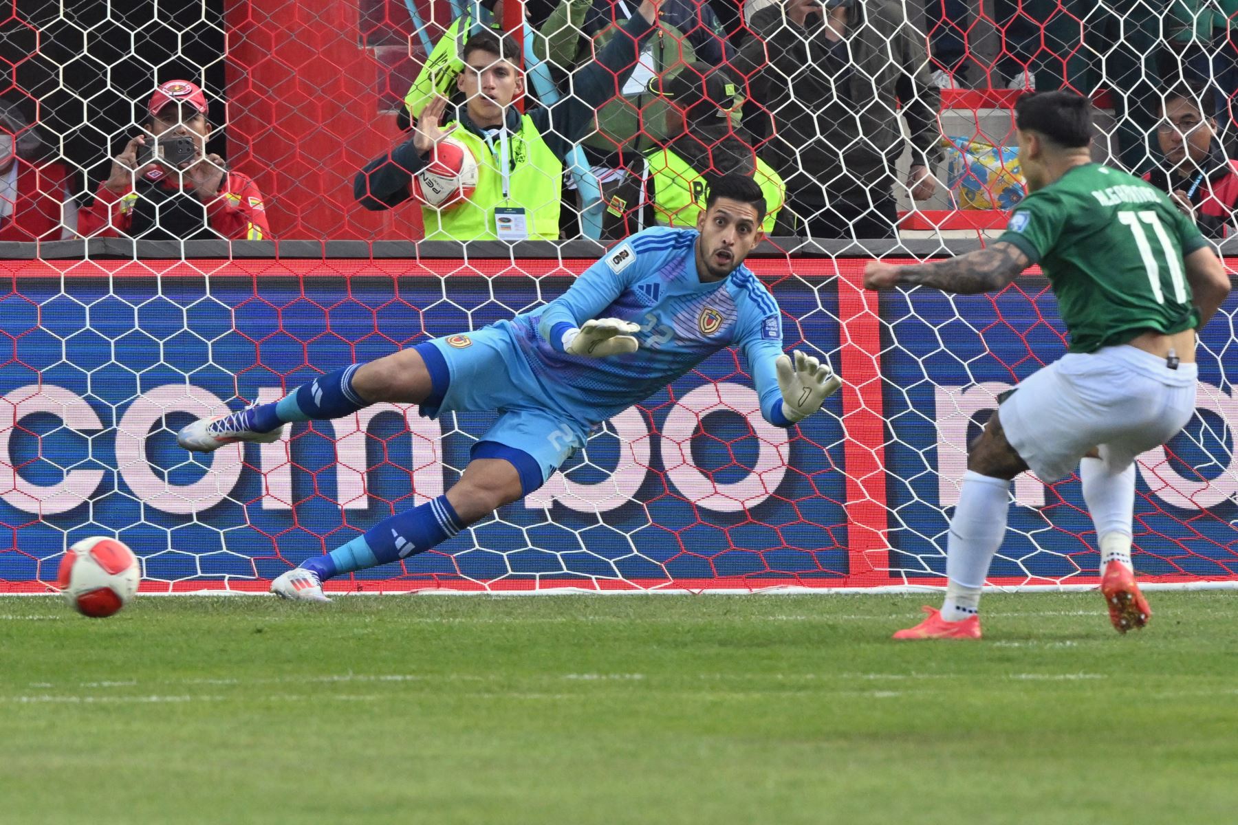 El delantero boliviano Carmelo Algarañaz (derecha) anota un penalti contra el portero venezolano Rafael Romo durante el partido de las eliminatorias sudamericanas para la Copa Mundial de la FIFA 2026 entre Bolivia y Venezuela. Foto: AFP