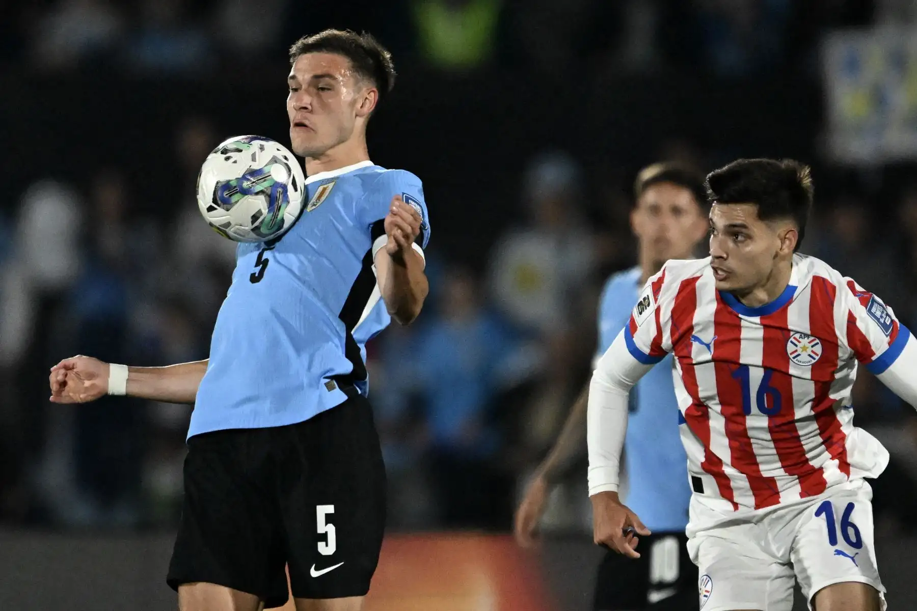 El mediocampista uruguayo Manuel Ugarte y el mediocampista paraguayo Damián Bobadilla luchan por el balón durante el partido de fútbol de las eliminatorias sudamericanas para la Copa Mundial FIFA 2026 entre Uruguay y Paraguay en el estadio Centenario de Montevideo. Foto: AFP