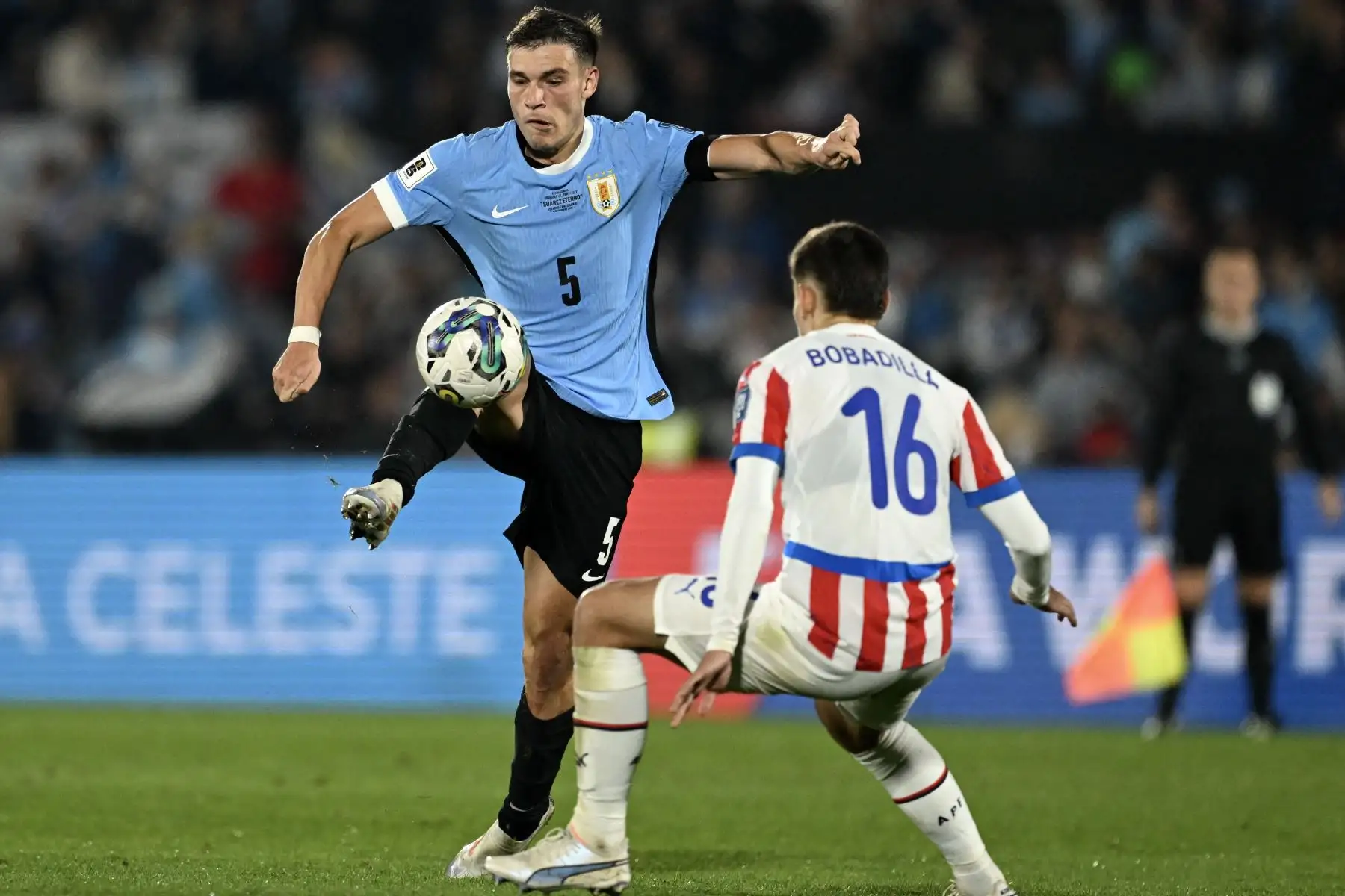 El mediocampista uruguayo Manuel Ugarte y el mediocampista paraguayo Damián Bobadilla luchan por el balón durante el partido de fútbol de las eliminatorias sudamericanas para la Copa Mundial FIFA 2026 entre Uruguay y Paraguay en el estadio Centenario de Montevideo. Foto: AFP