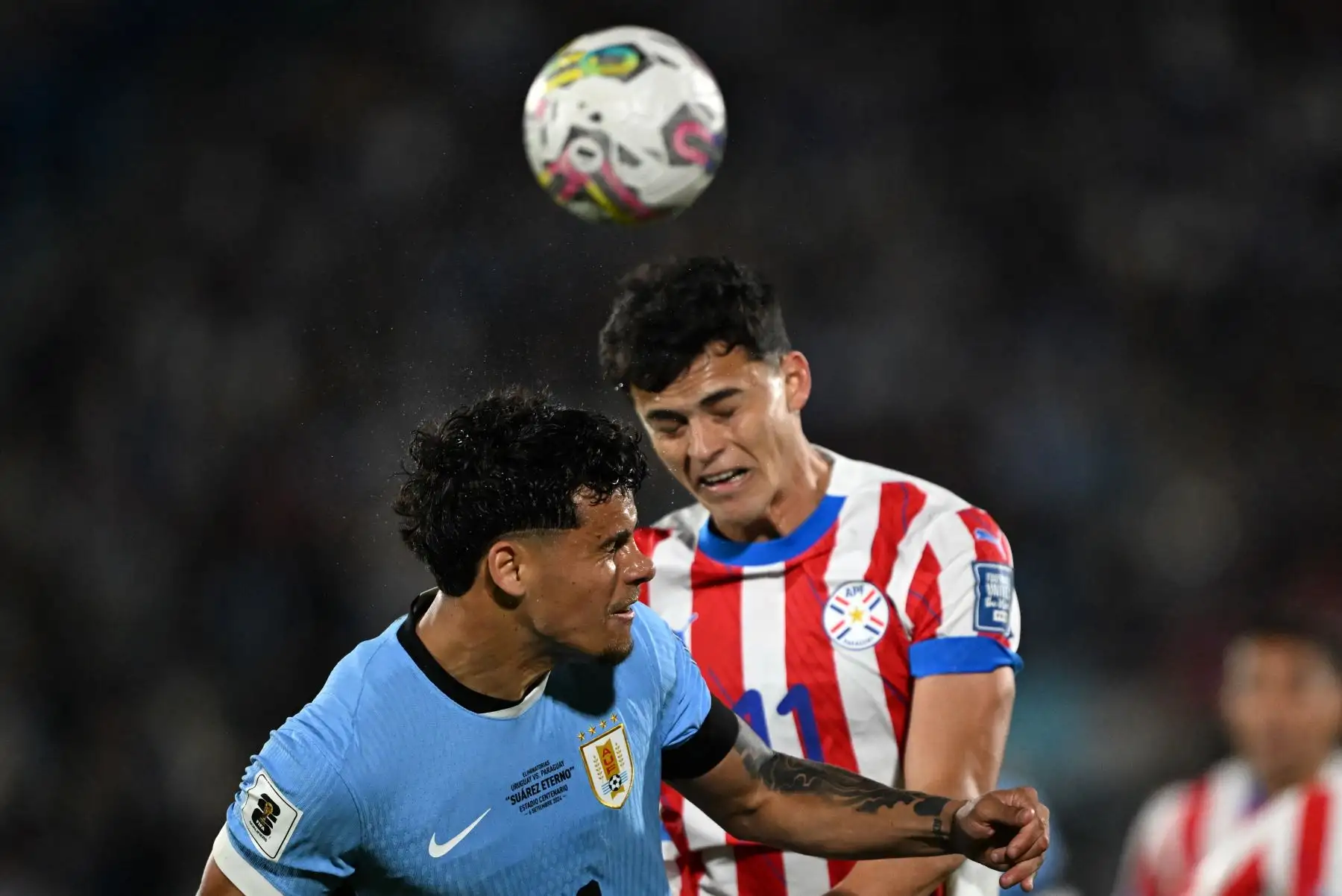 El mediocampista uruguayo Maximiliano Araujo y el delantero paraguayo Ramón Sosa luchan por el balón durante el partido de fútbol de las eliminatorias sudamericanas para la Copa Mundial FIFA 2026 entre Uruguay y Paraguay en el estadio Centenario de Montevideo. Foto: AFP