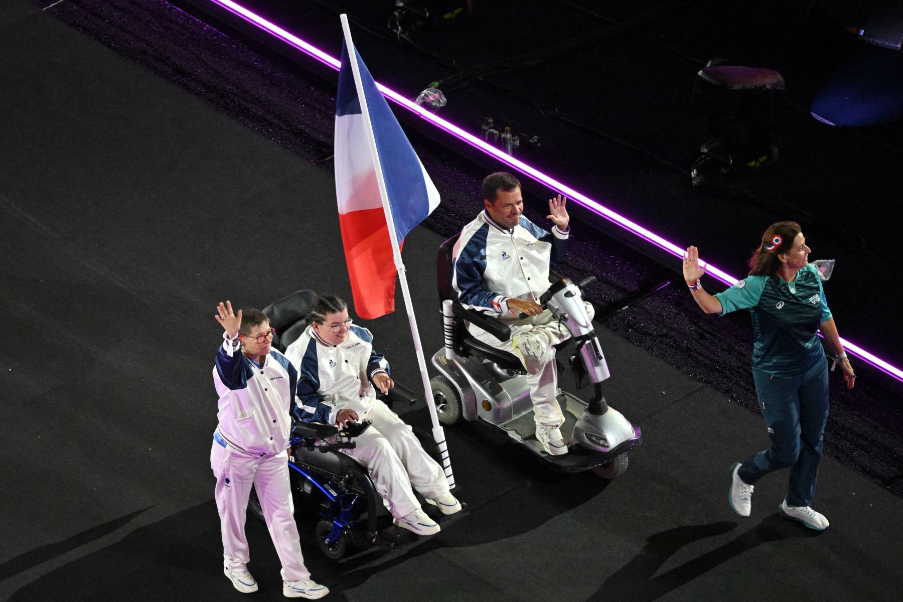 La francesa Aurelie Aubert  y la francesa Tanguy De La Forest  desfilan en el escenario durante la ceremonia de clausura de los Juegos Paralímpicos de París 2024.
Foto: AFP