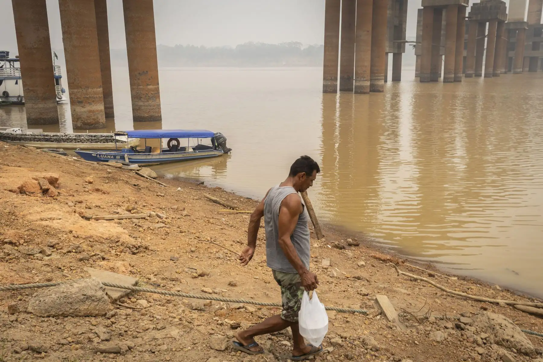 Un hombre camina cerca del puente Rondon-Roosevelt, al lado del río Madeira con nivel bajo de caudal este lunes en Porto Velho, en el estado de Rondonia (Brasil). 
Foto: EFE