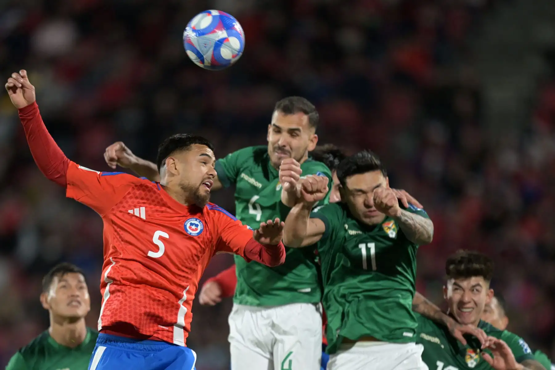 El defensor chileno Paulo Díaz  encabeza el balón contra el defensor boliviano Luis Haquin  y el delantero boliviano Carmelo Algarañaz durante el partido de fútbol de las eliminatorias sudamericanas para la Copa Mundial de la FIFA 2026 entre Chile y Bolivia, en el Estadio Nacional de Santiago.
Foto: AFP